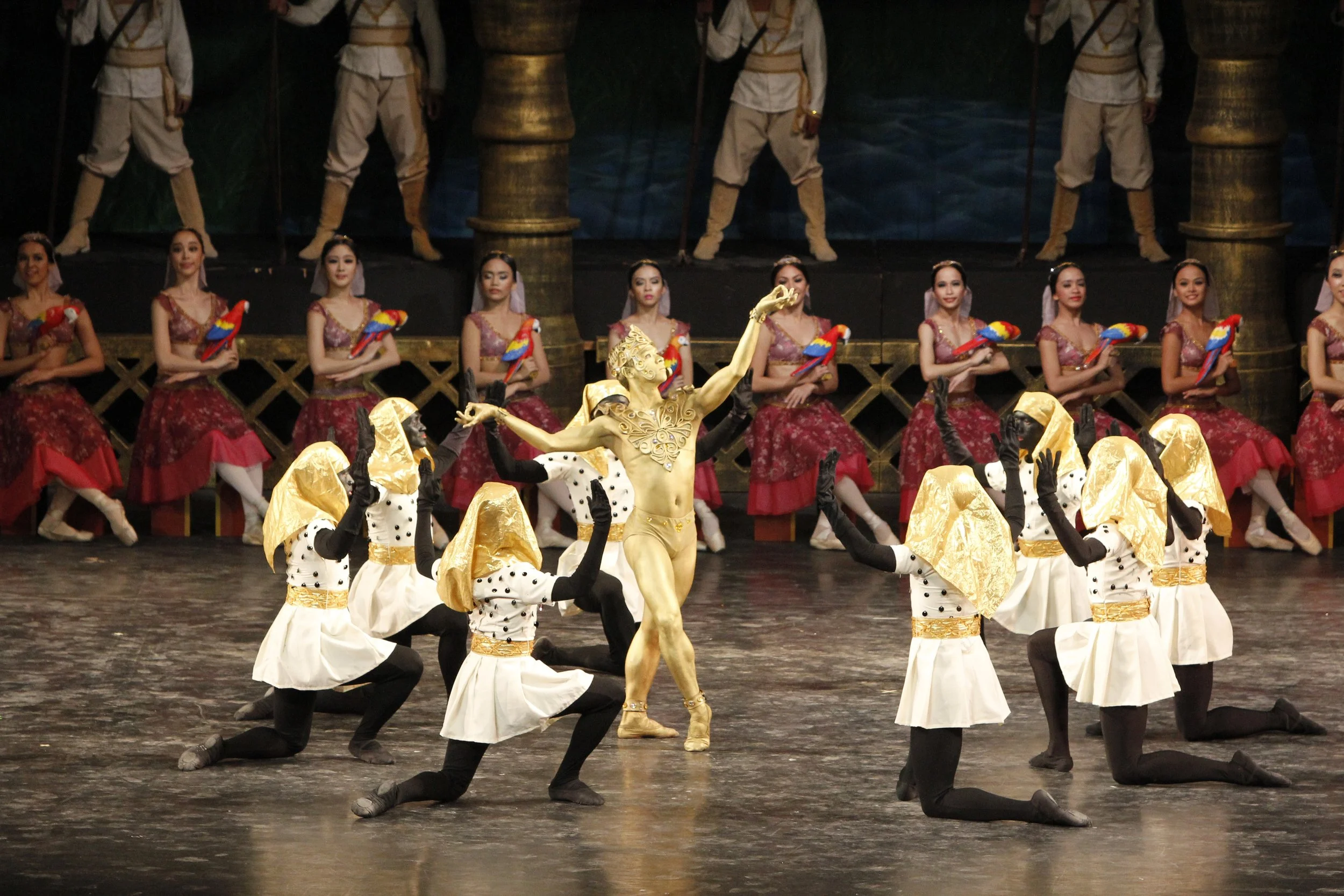    In  La Bayadere  (2014), the glimmer of the Bronze Idol (also referred to as the Golden Idol) played by Gerardo Francisco Jr. is complemented by the touches of gold in the accompanying dancers’ costumes. The  Bronze Idol Variation  may only be a f