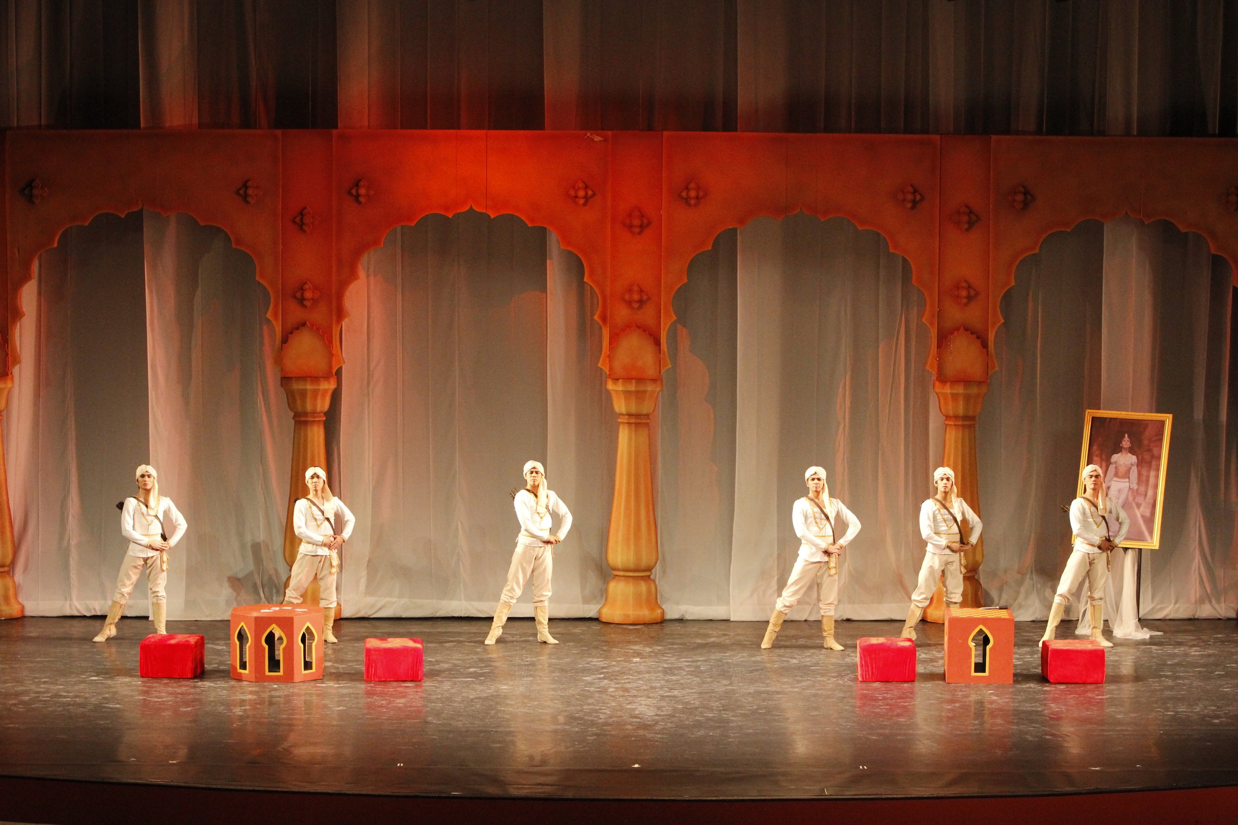    In the 2013 staging of  La Bayadere,  soldiers stand guard at the palace room where Gamzatti is shown a portrait of Solor and falls for him, not knowing that he has already pledged his love for Nikiya before the eternal flame.&nbsp;   