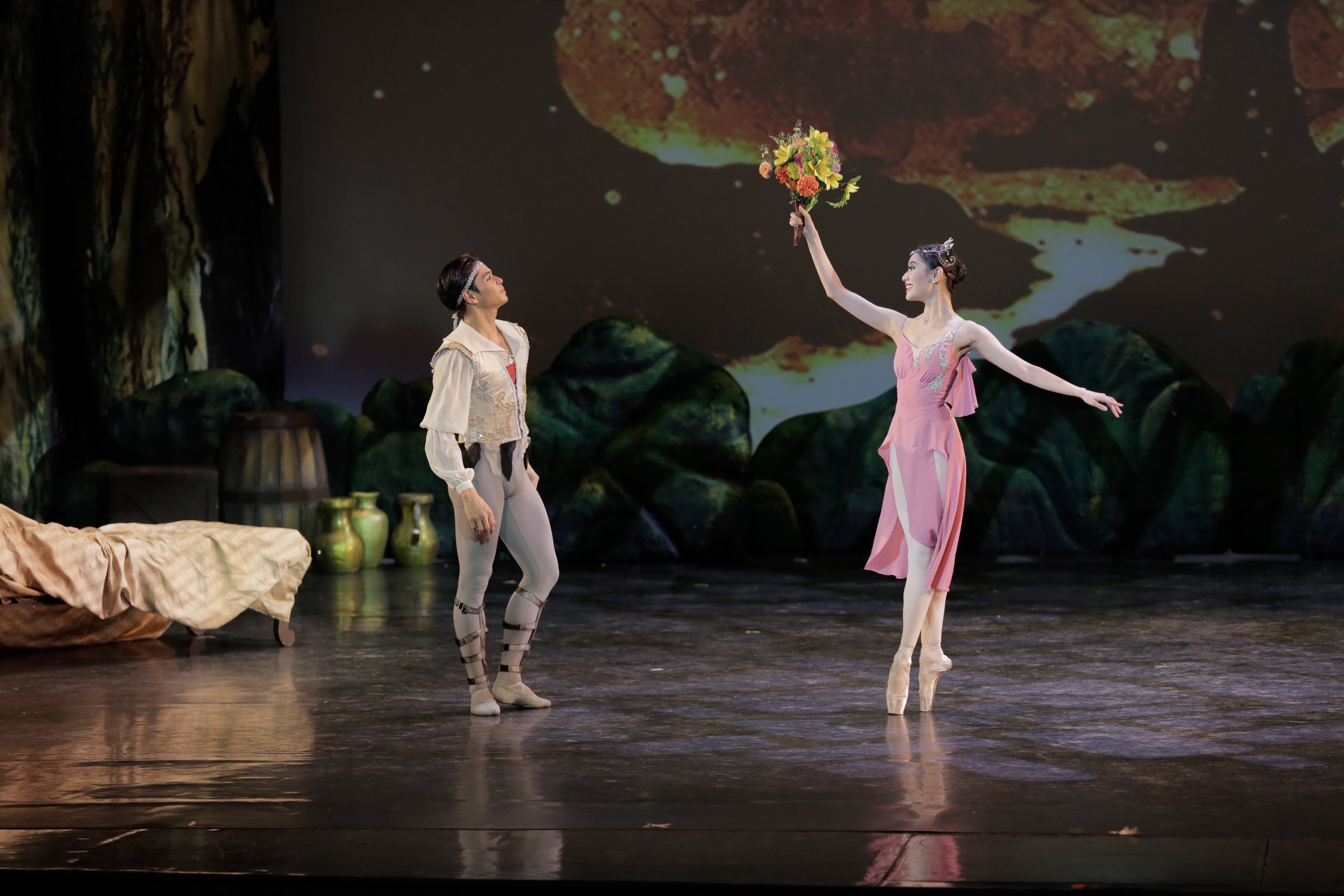    Medora (Abigail Oliveiro) joyfully shows Conrad (Mark Sumaylo) the bouquet of flowers she has just received in  Le Corsaire  (2018), unknowing of the fate that will soon befall them. The bouquet has been sprayed with a potion that puts Conrad to s