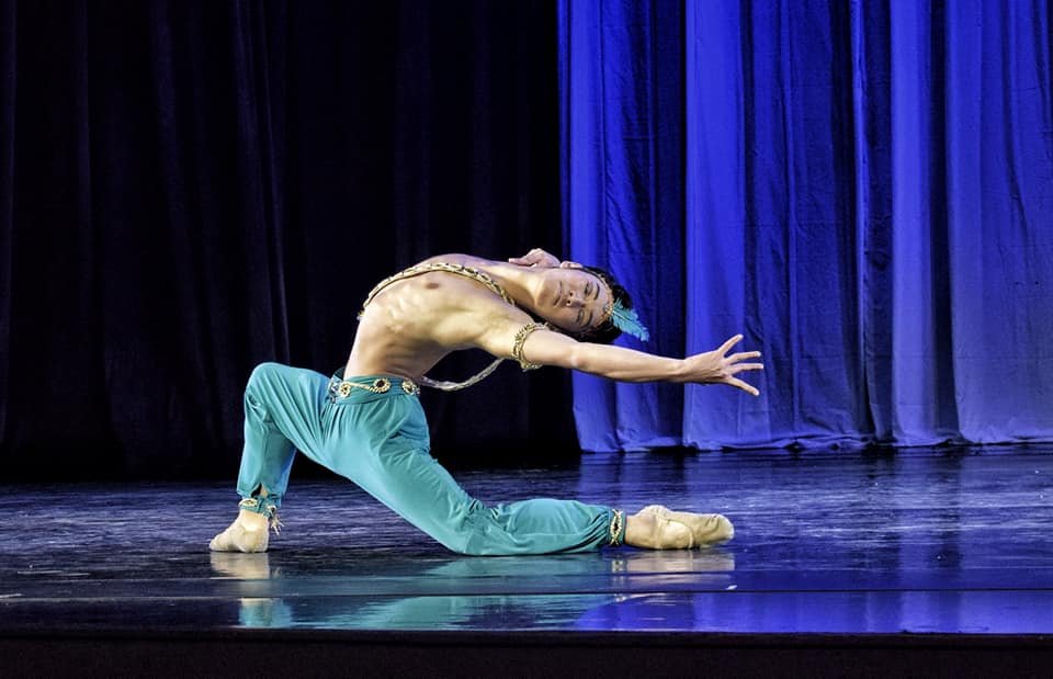    Wearing trademark blue harem pants, the loyal servant Ali figures prominently in the pirate adventure,  Le Corsaire . Here, guest artist Hyuma Kiyosawa gets to dance the famous Ali Variation in  Deux  (2019), the production that capped Ballet Mani