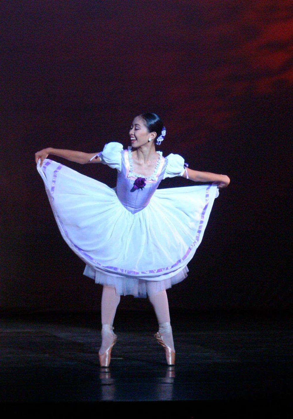    Holding up the skirt of her lilac and white tutu, Marian Faustino is playful and full of energy as she dances the solo part in August Bournonville’s  Kermesse in Bruges  pas de deux. The piece was performed in  OPM at OPB  (2003) where she was par