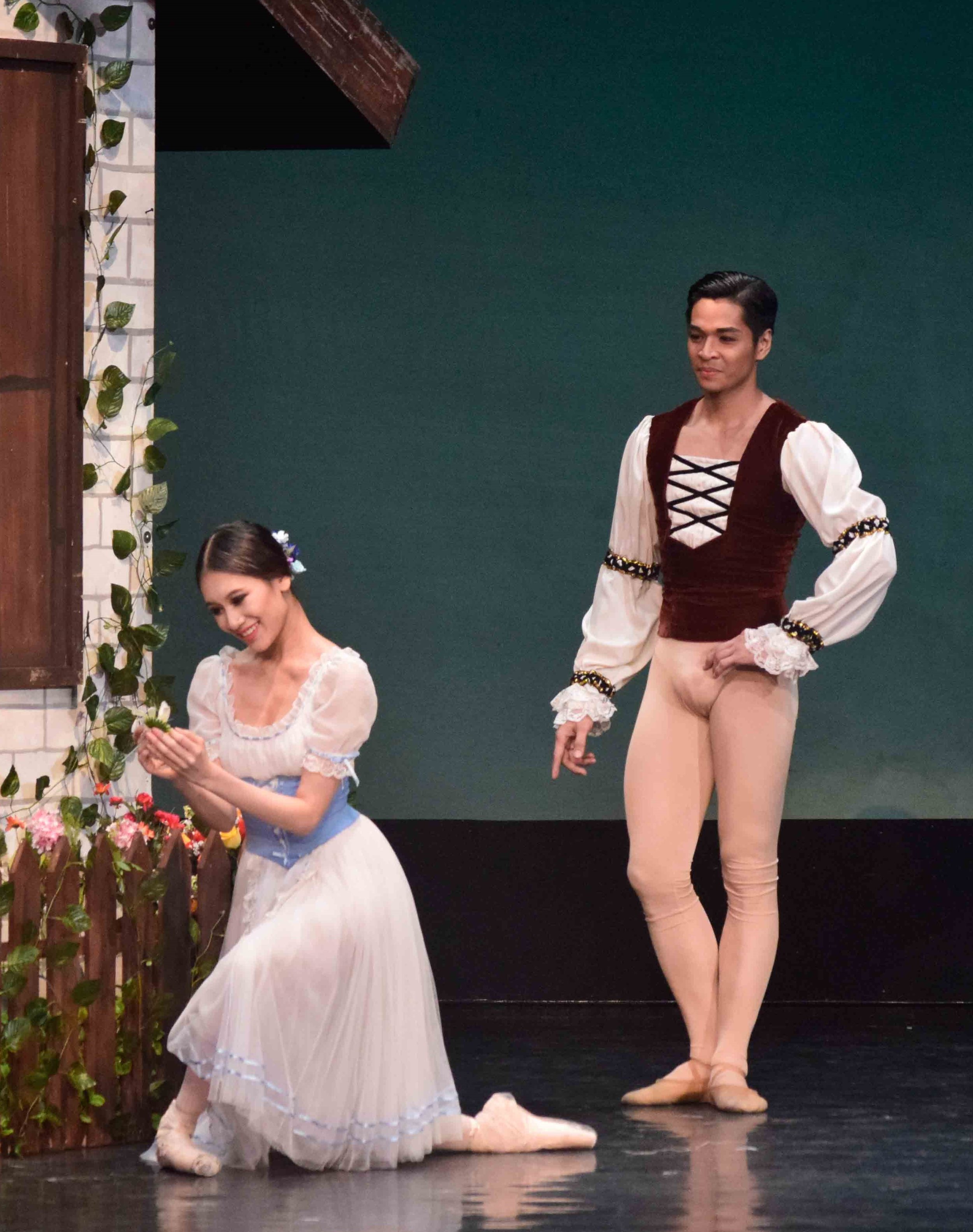    After Albrecht (Mark Sumaylo) gives her a daisy, Giselle (Abigail Oliveiro) playfully plucks each petal off in a game of “He loves me, he loves me not.” The scene is from  Giselle  which the real-life couple danced for the first time together in i