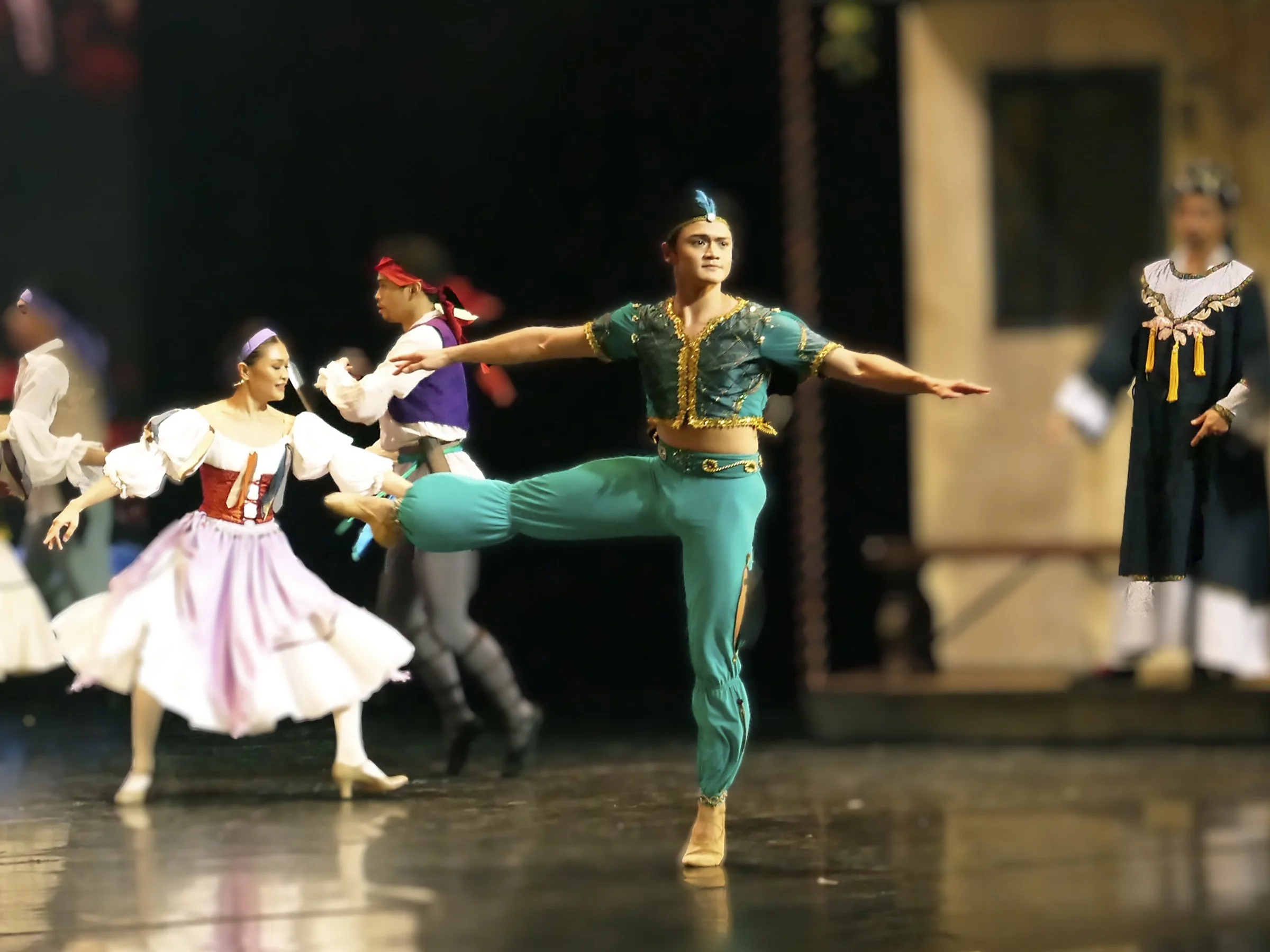    Garbed in an all-teal ensemble with flecks of gold, Ali (Joshua Enciso) is the loyal servant to the pirate Conrad in  Le Corsaire  (2023). The character figures prominently in the adventure as he saves his master from the scheming Birbanto and hel