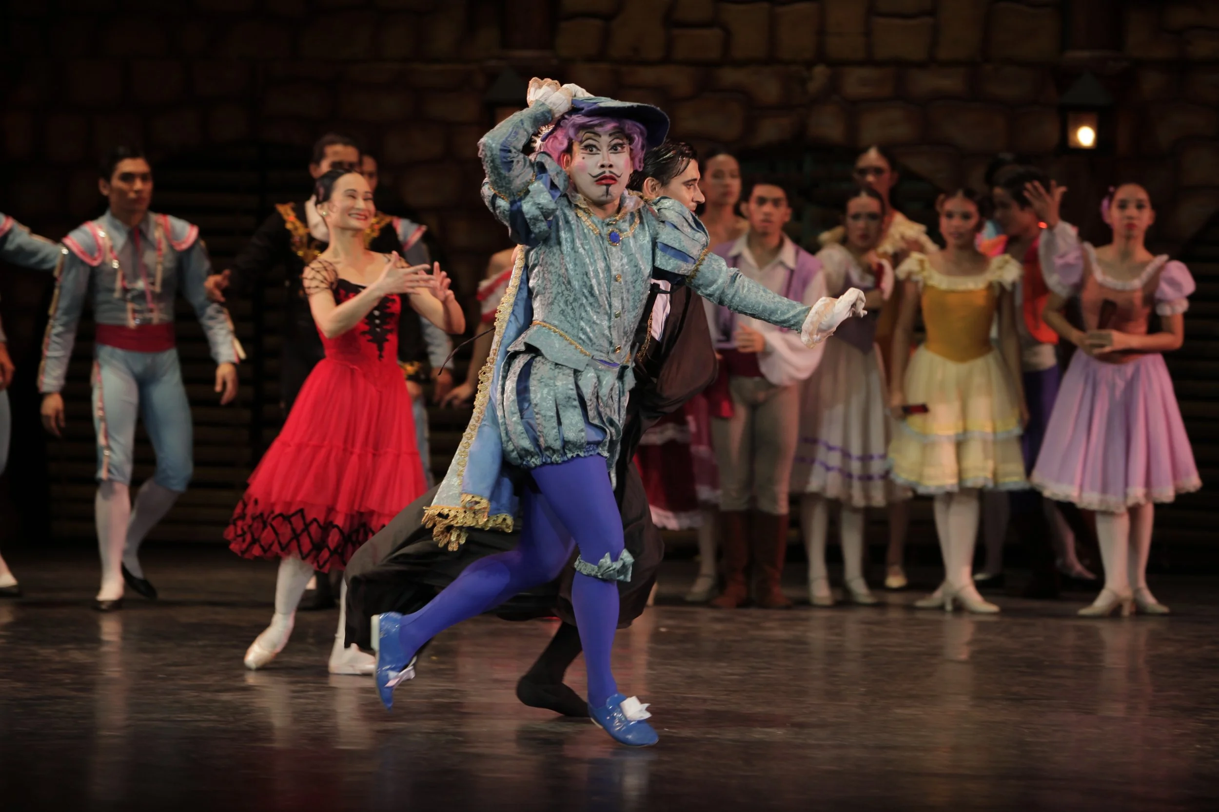    After his elaborate hairpiece reveals a bald head, a stunned Gamache (Jonathan Janolo) is led away by Basilio (Mikhail Martynyuk) as Kitri (Lisa Macuja Elizalde) gleefully cheers at finally being rid of her unwanted suitor. Every inch the town dan