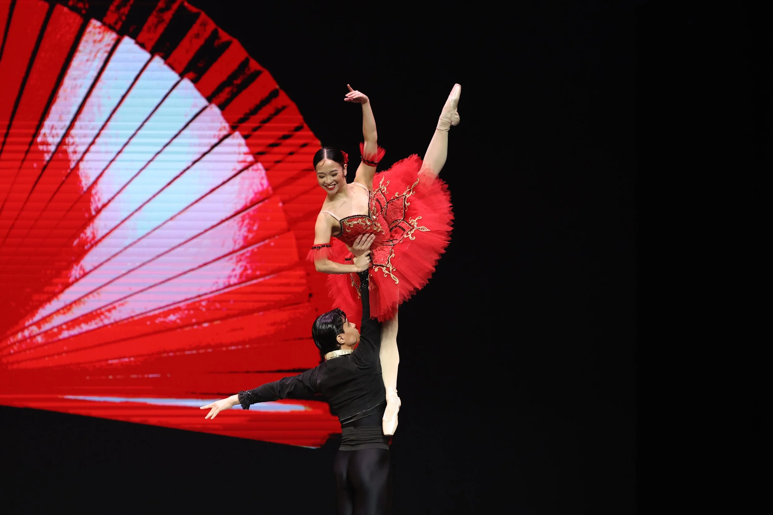    Radiant in red, Kitri (Jasmine Pia Dames) is held aloft by Basilio (Noah Esplana) with just one hand. The iconic move is a favorite in  Don Quixote,  the pas de deux from which was performed by this pair in  Ballet Manila’s Greatest Hits  in Malay