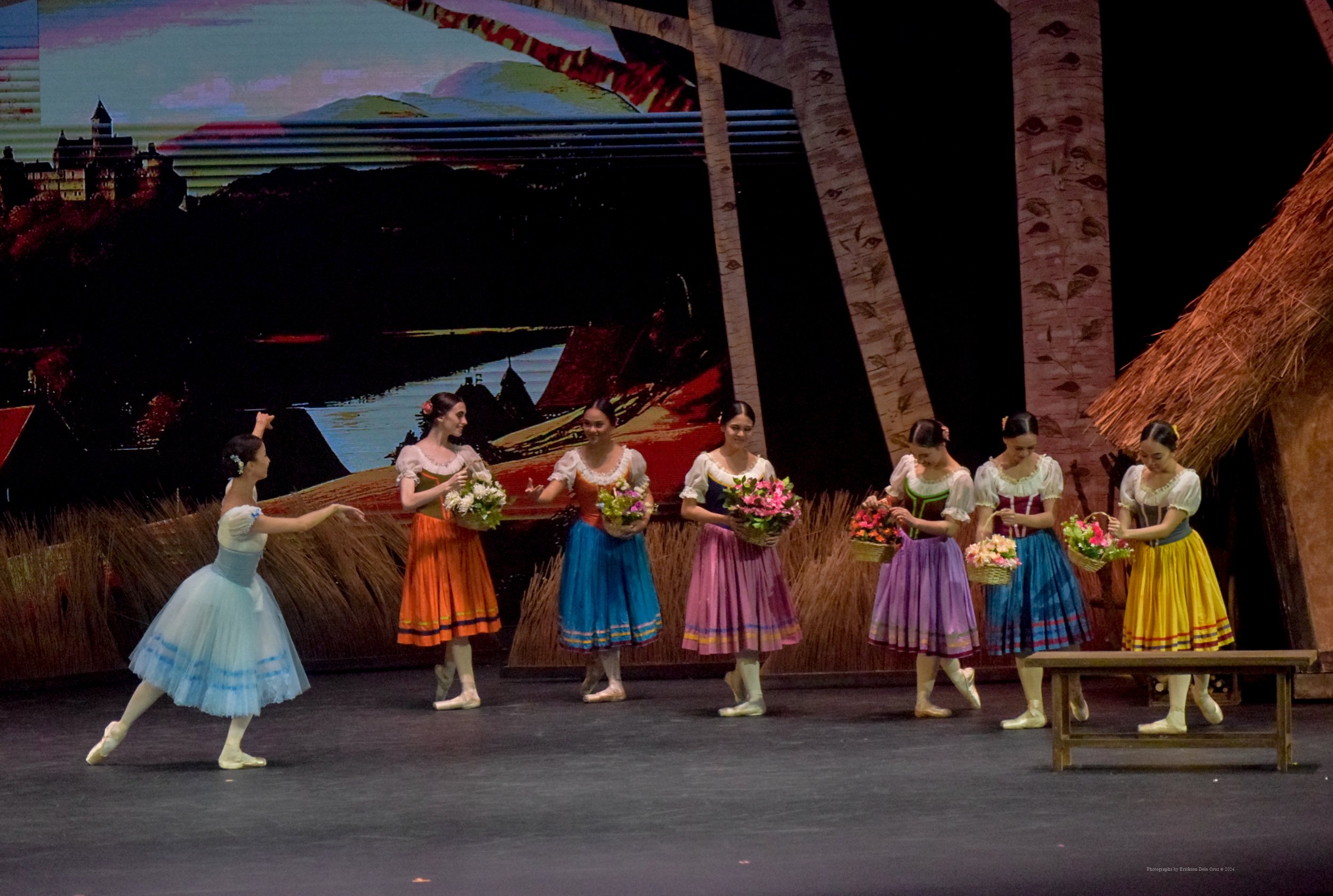    Village girl Giselle (Renata Shakirova, left) joins her friends who have just been out in the fields gathering flowers in this scene from  Giselle  (2024). The day is full of joy and lightness, in contrast to what is to happen as the story unfolds