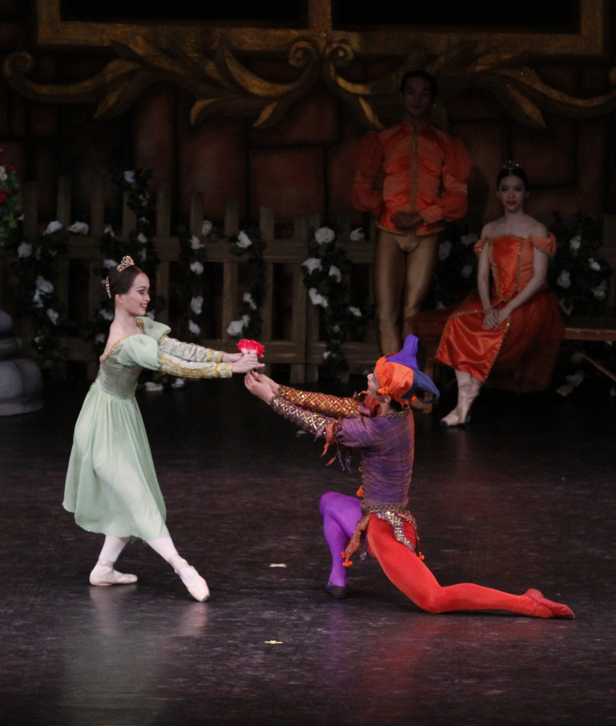    The Jester (Elpidio Magat) presents a rose to one of the two court ladies (Yanti Marduli) he has just danced with in S wan Lake  (2011). The pas de trois variation in Act 1 is performed for Prince Siegfried’s coming-of-age festivities. Photo by Oc