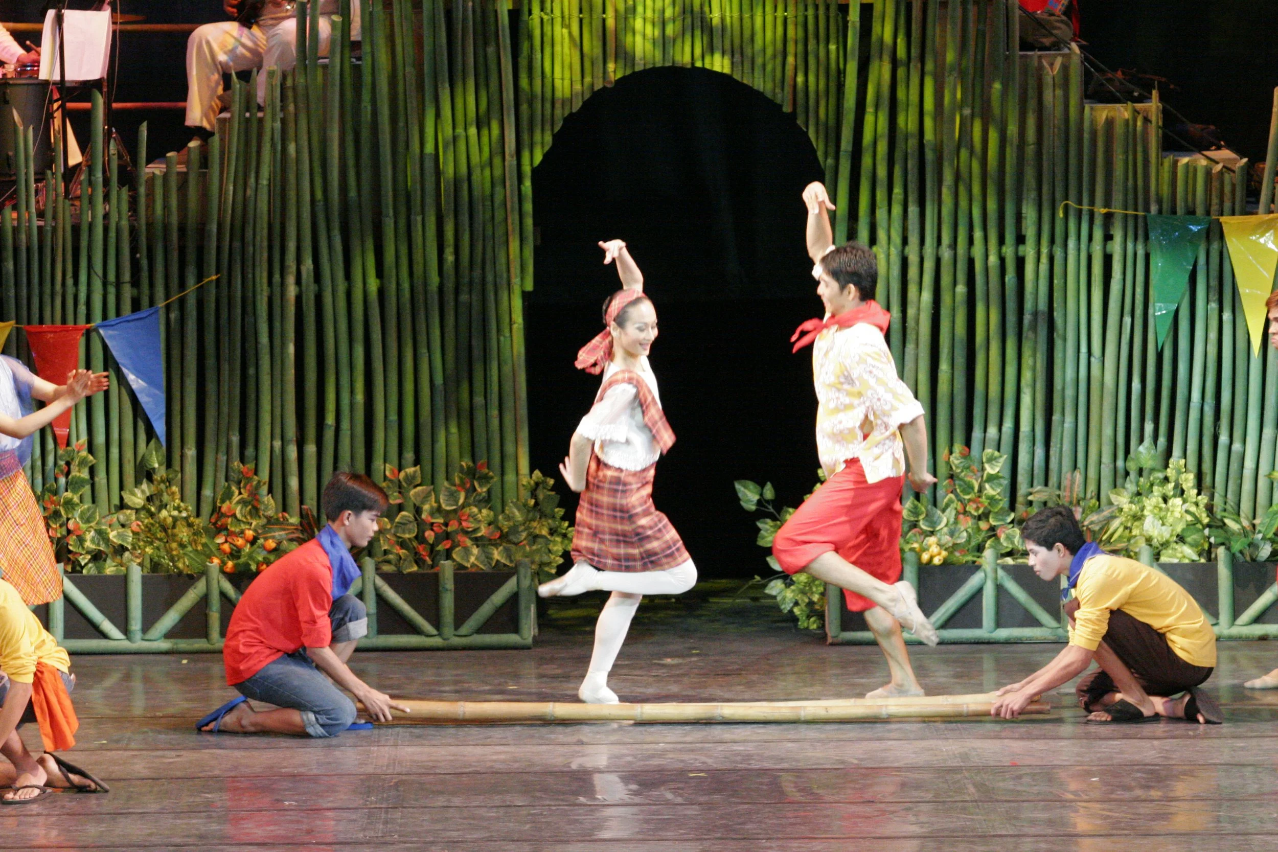    Lisa Macuja Elizalde and Nazer Salgado test their mettle in the  tinikling .  Tinikling  mimics the quick movements of the tikling bird as it walks through grass and dodges bamboo traps.   