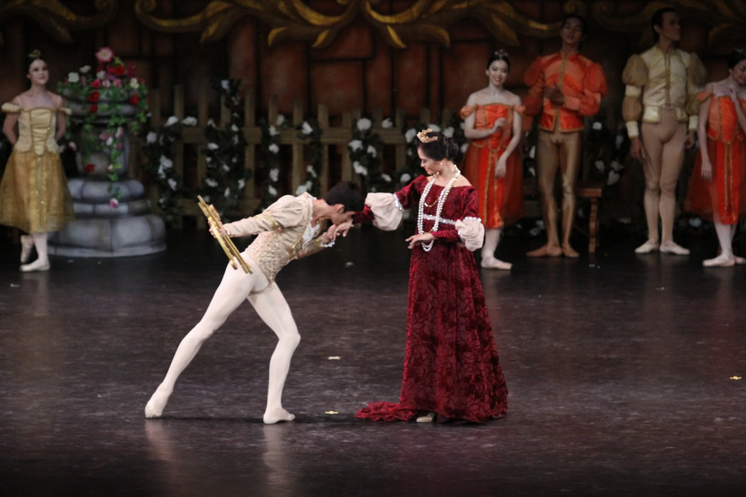    Resplendent in her gown in the lush color of maroon, the Queen (Janine Togonon) looks fondly at her son Siegfried (Nazer Salgado) as he kisses her hand, in gratitude for the gift he has just received from her – a bow he can use for his forays into