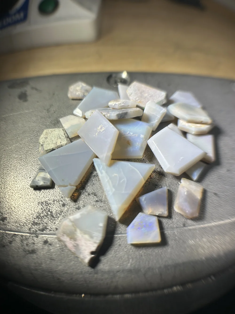 Pale opal pieces on Andrea Li's steel bench block, the most fragile stones she set in her Tamar collection