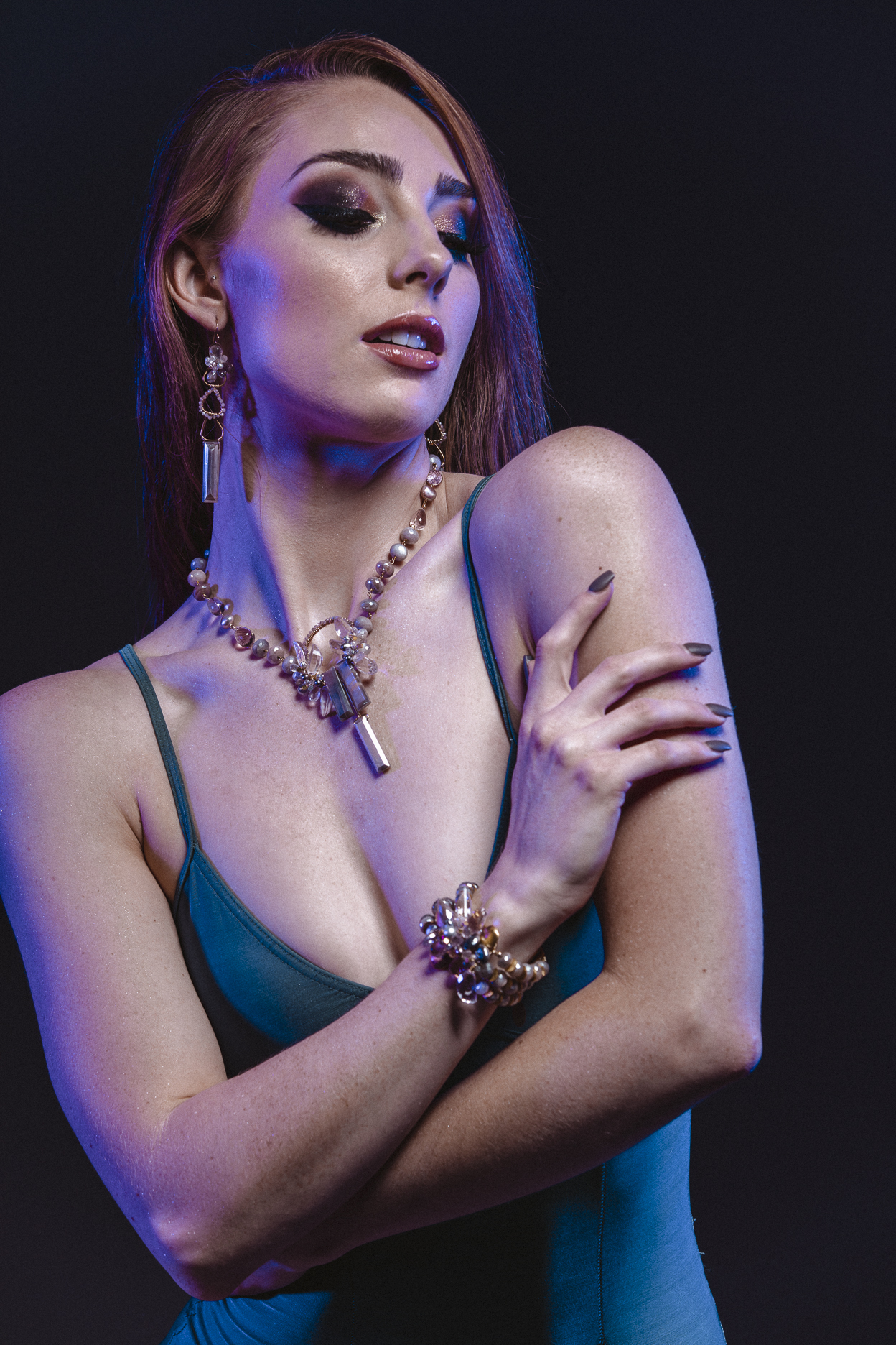 Model wearing pendant gemstone necklace, earrings and cuff bracelet
