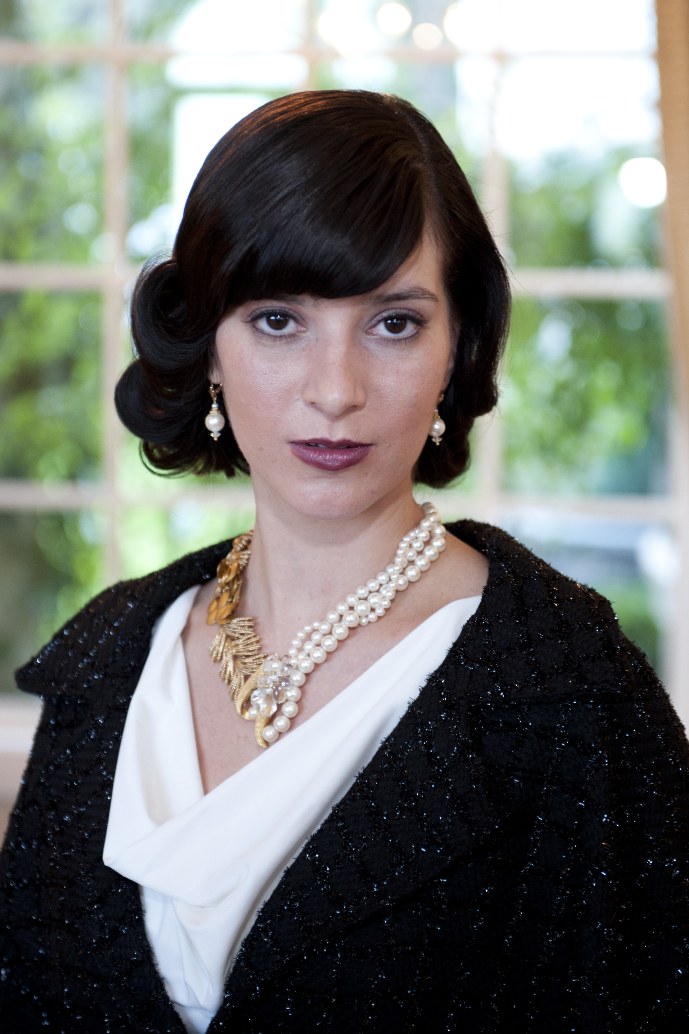 model wearing multi strand pearl necklace with gold details