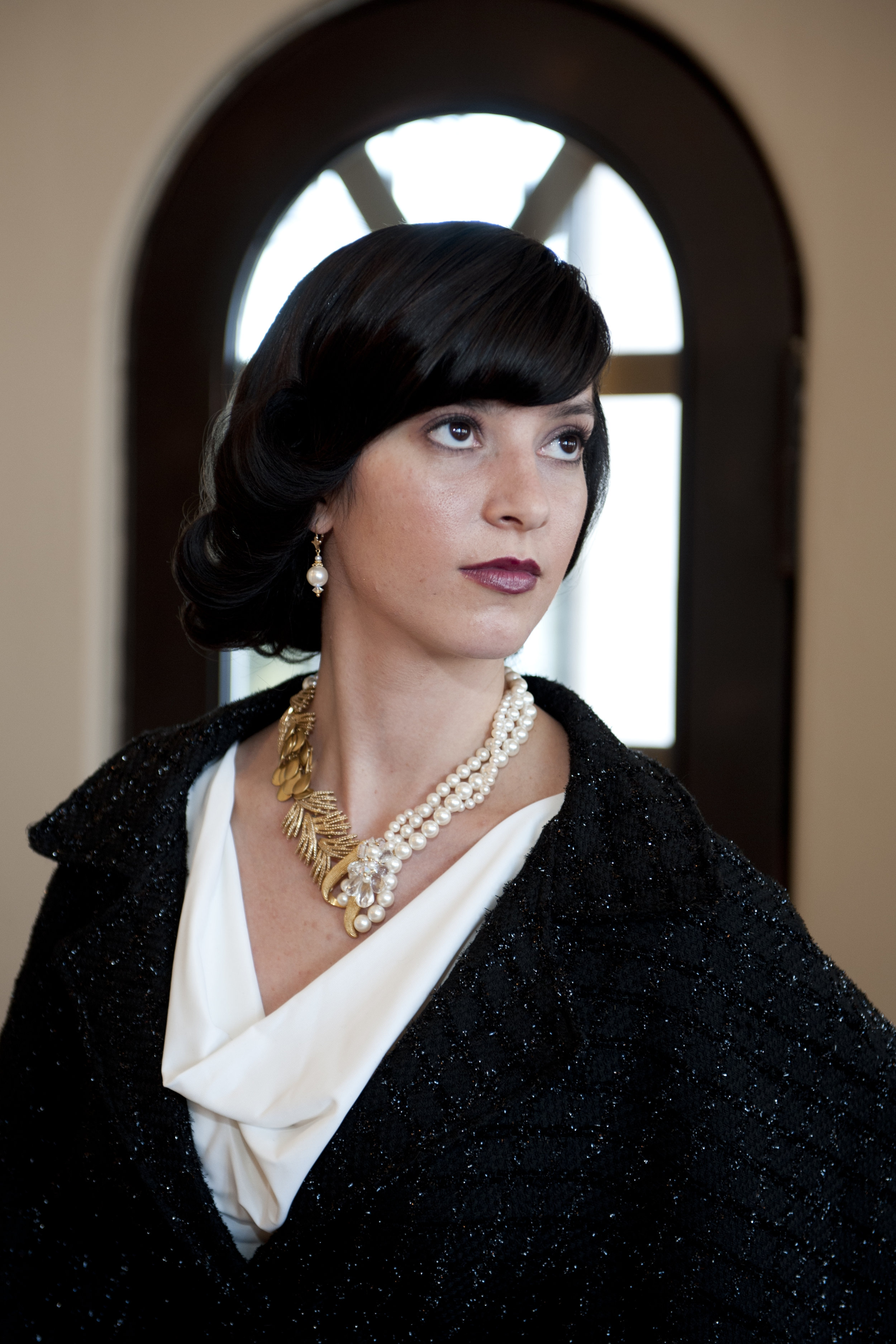 model wearing multi strand pearl necklace with gold details