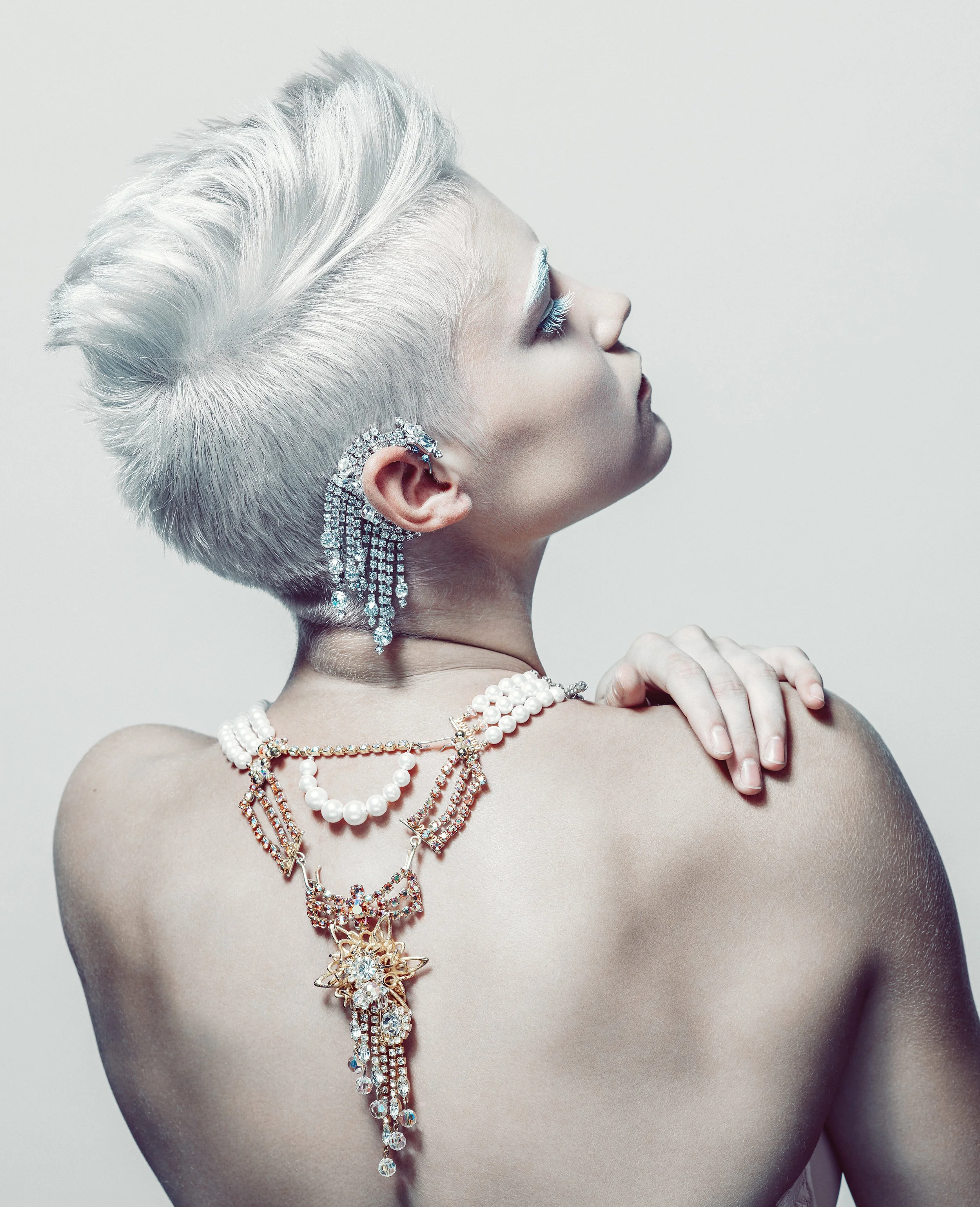 model wearing triple strand pearl and vintage rhinestone statement necklace