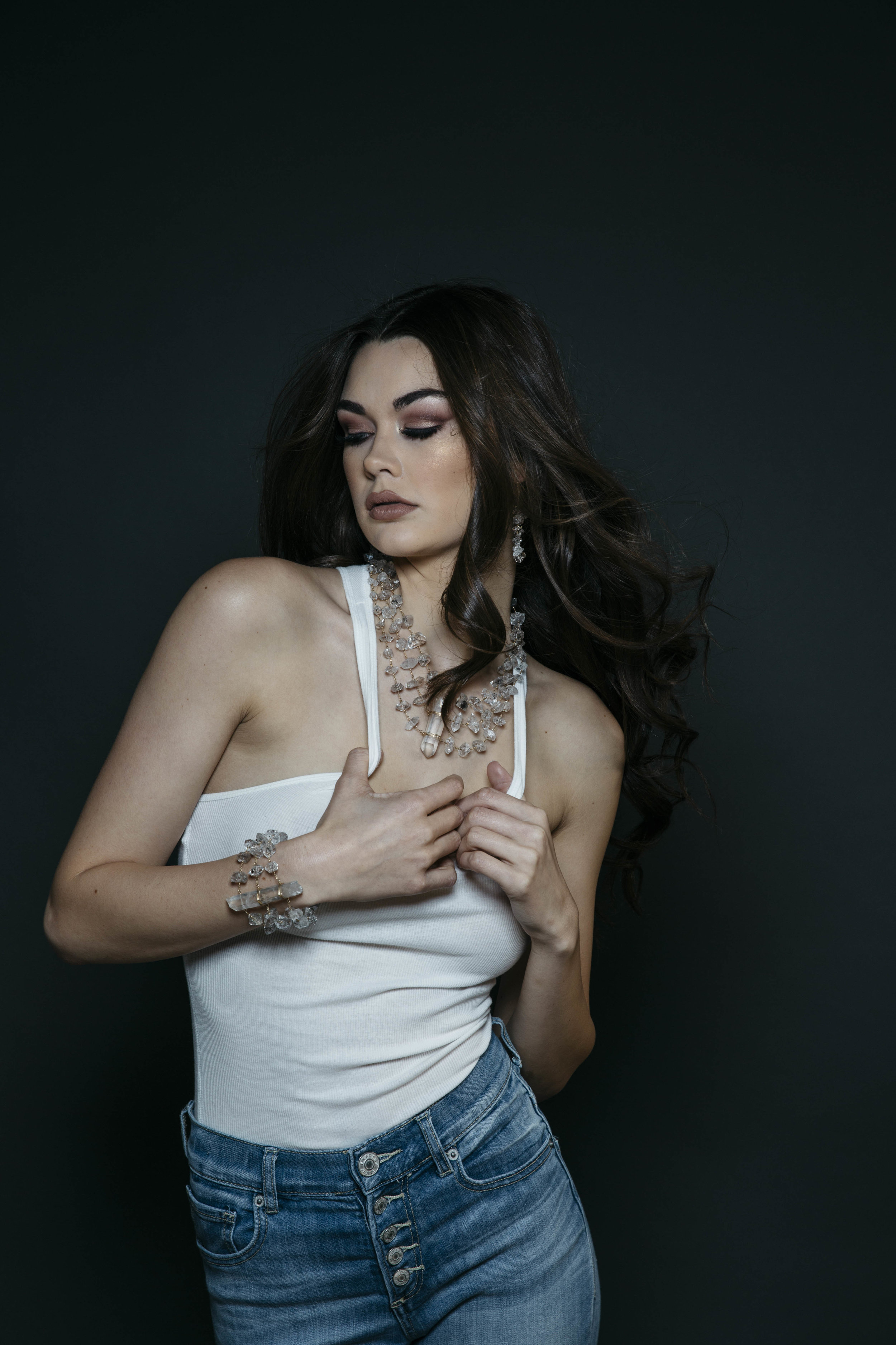 Model wearing a triple strand herkimer diamond statement cuff bracelet with a long crystal point centerpiece