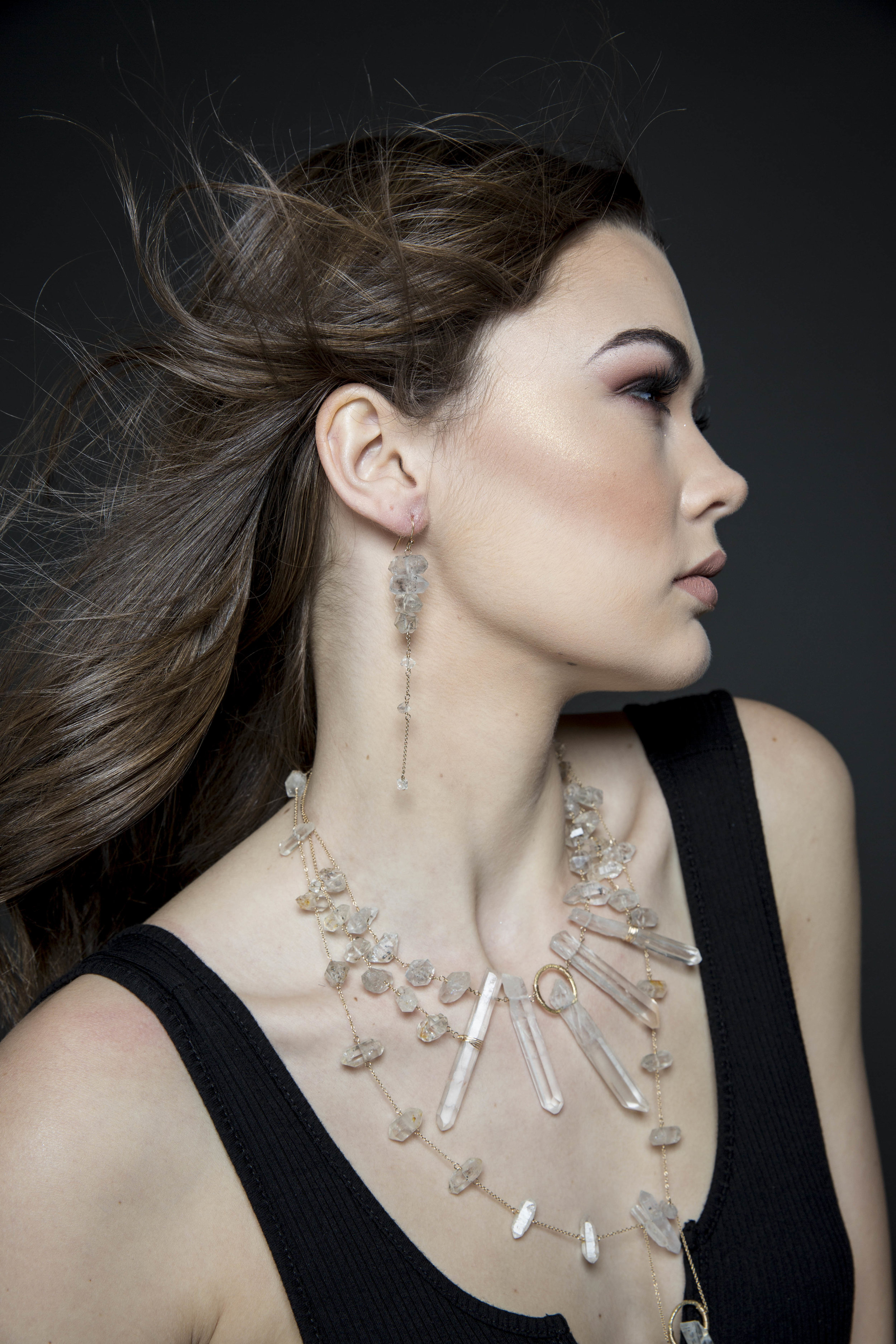 Model wearing tiered crystal long earrings