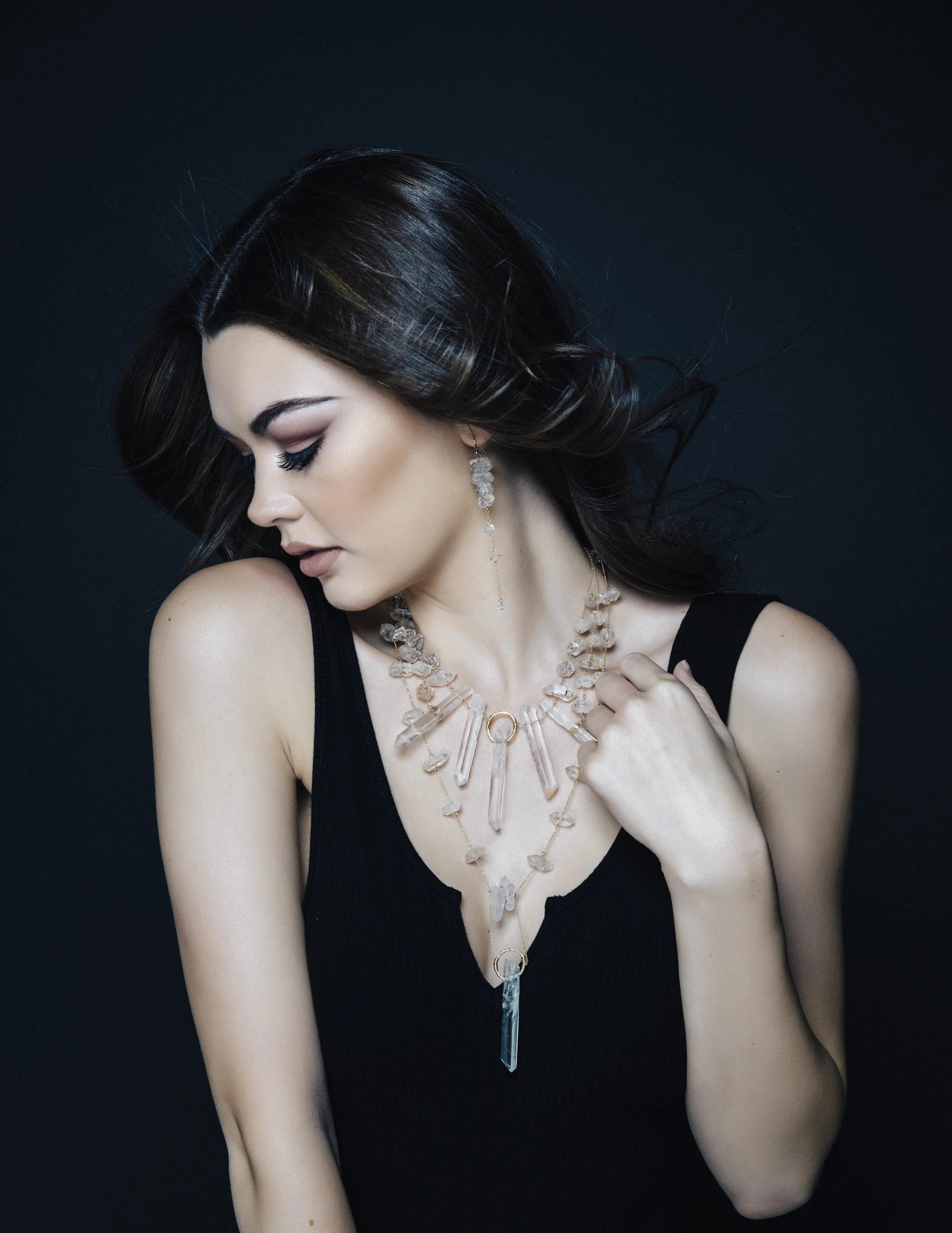 Model wearing tiered crystal long earrings
