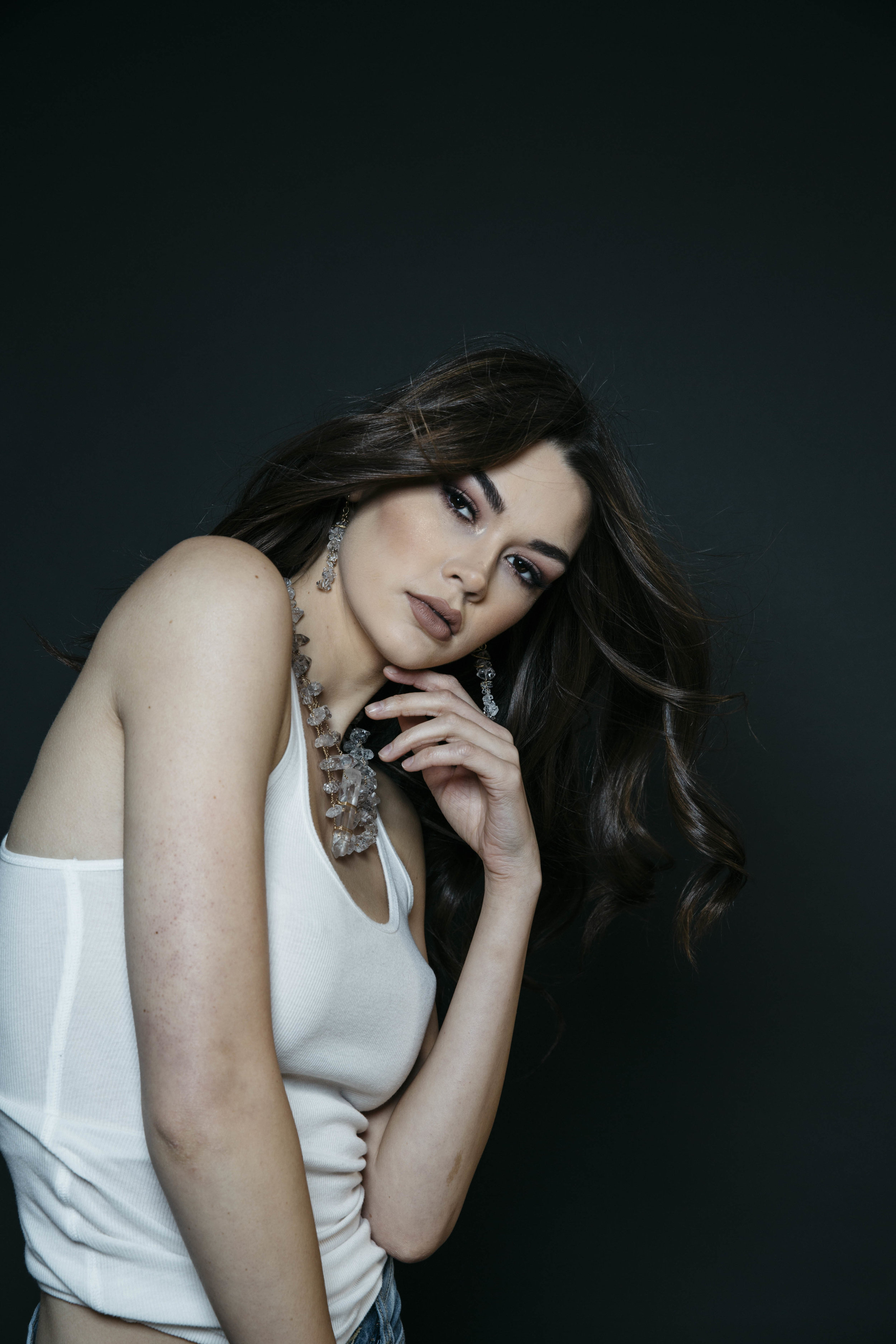 Model wearing a triple strand herkimer diamond statement necklace with a large crystal point pendant