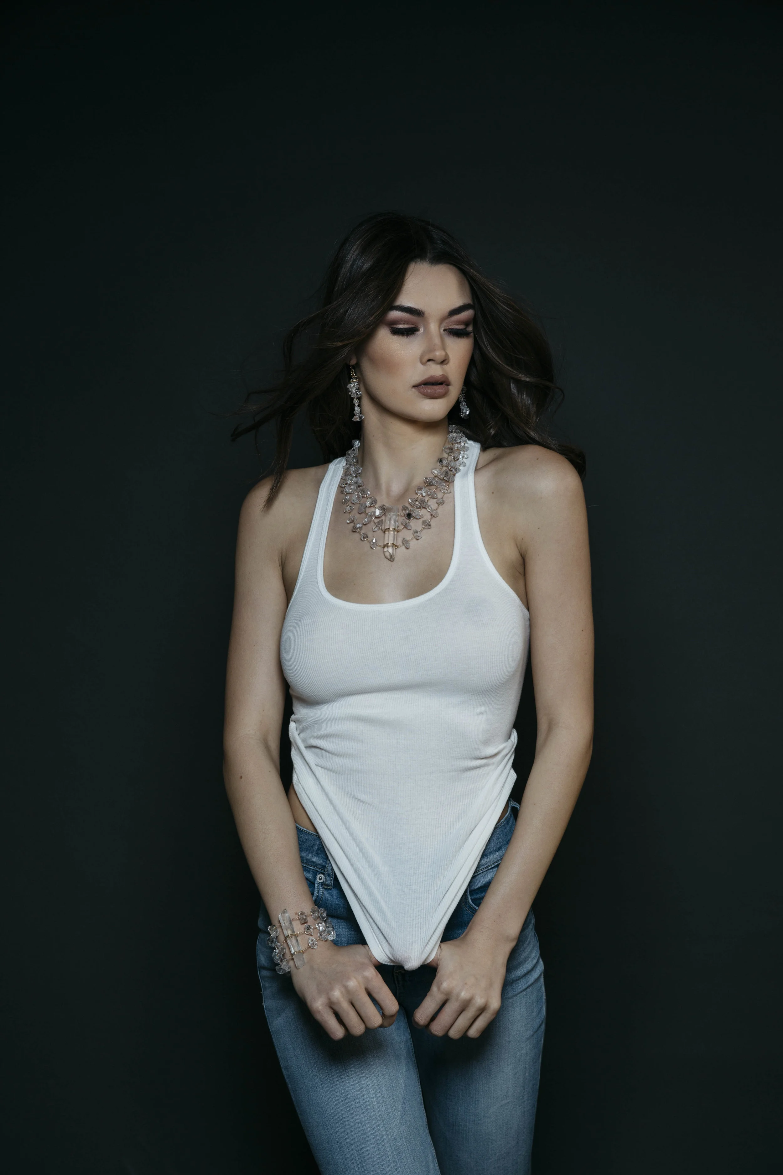 Model wearing a triple strand herkimer diamond statement necklace with a large crystal point pendant