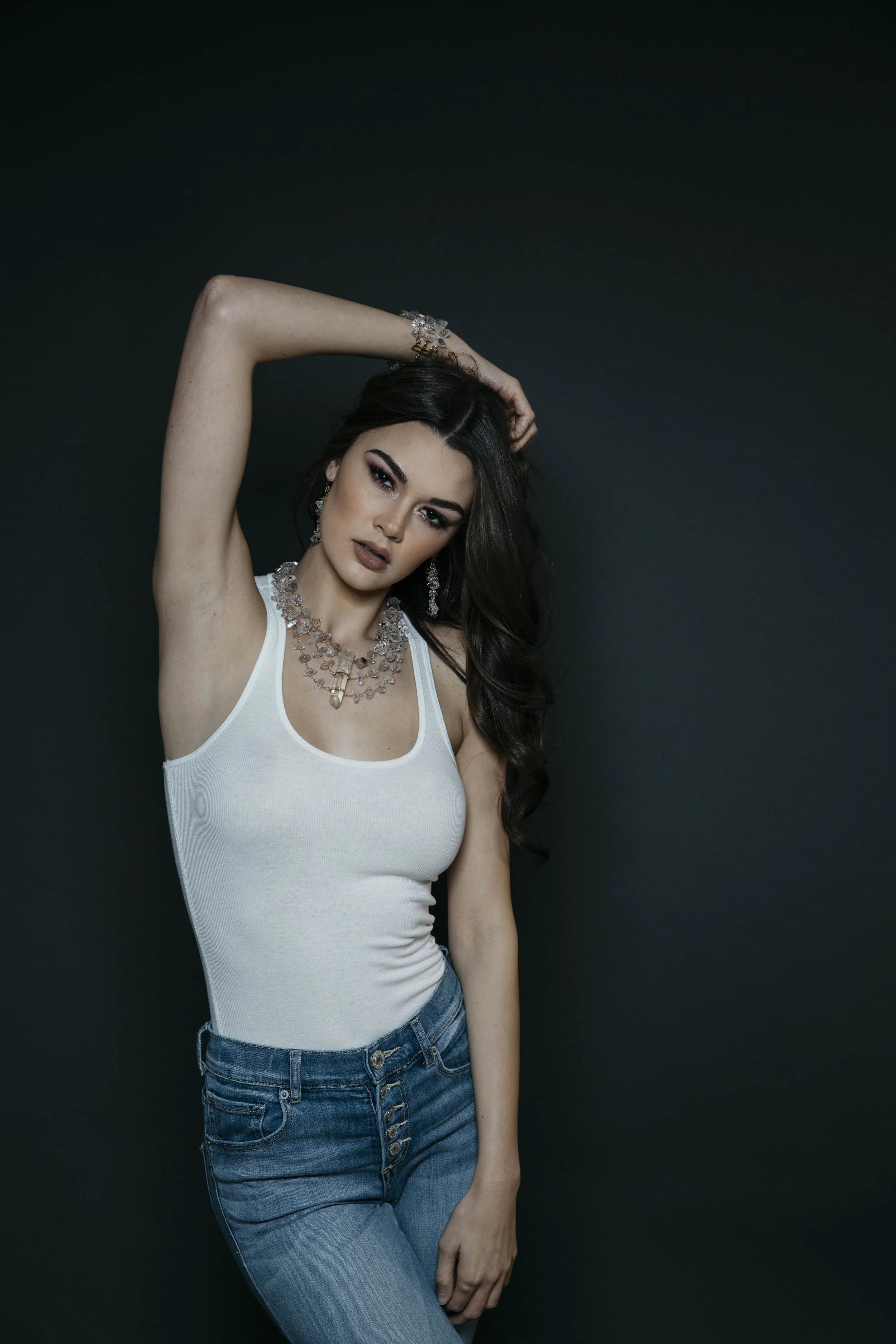 Model wearing a triple strand herkimer diamond statement necklace with a large crystal point pendant