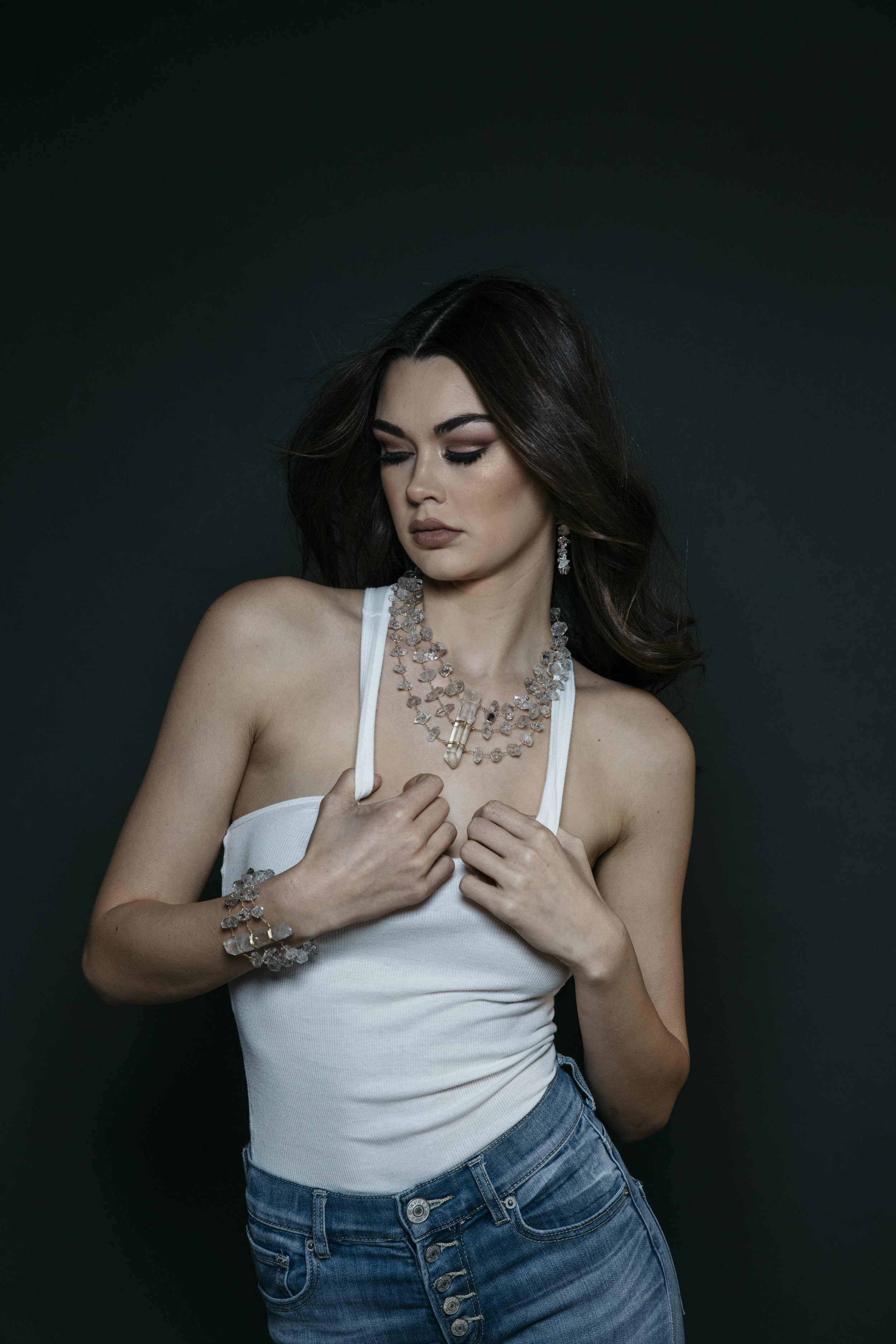 Model wearing a triple strand herkimer diamond statement necklace with a large crystal point pendant