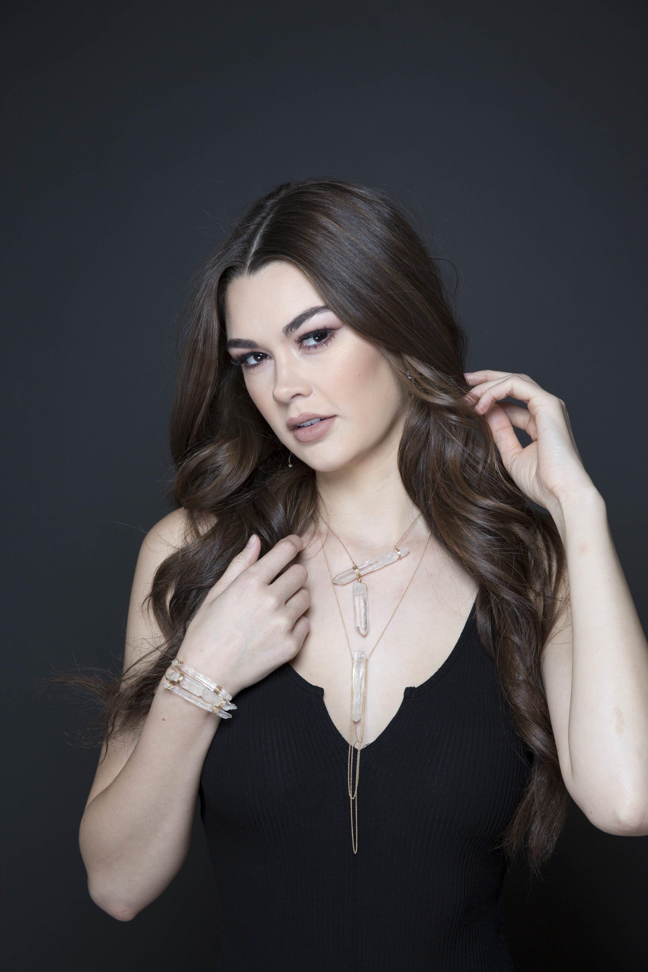 model wearing a crystal point pendant with draping gold chains necklace