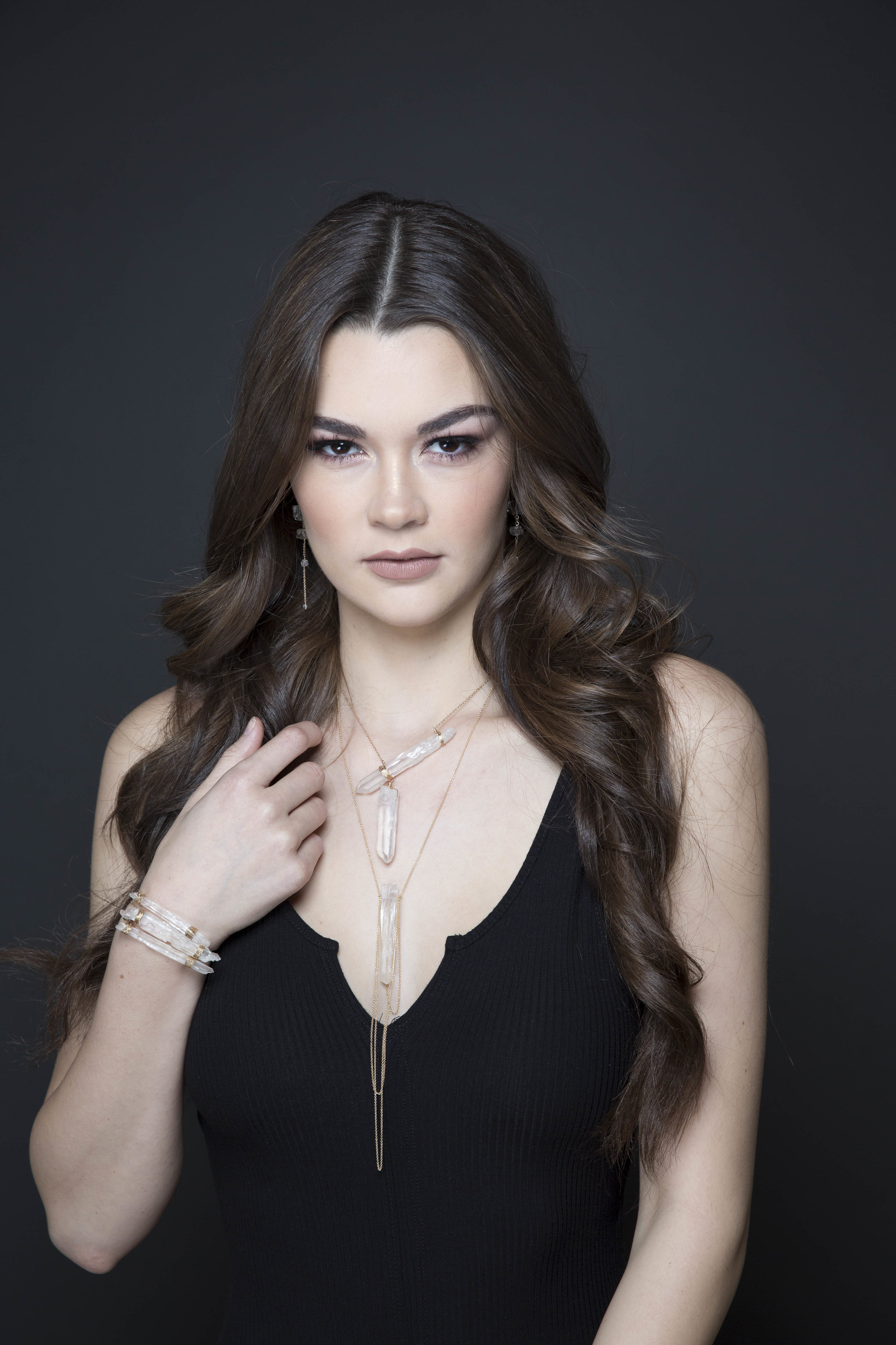 model wearing a crystal point pendant with draping gold chains necklace