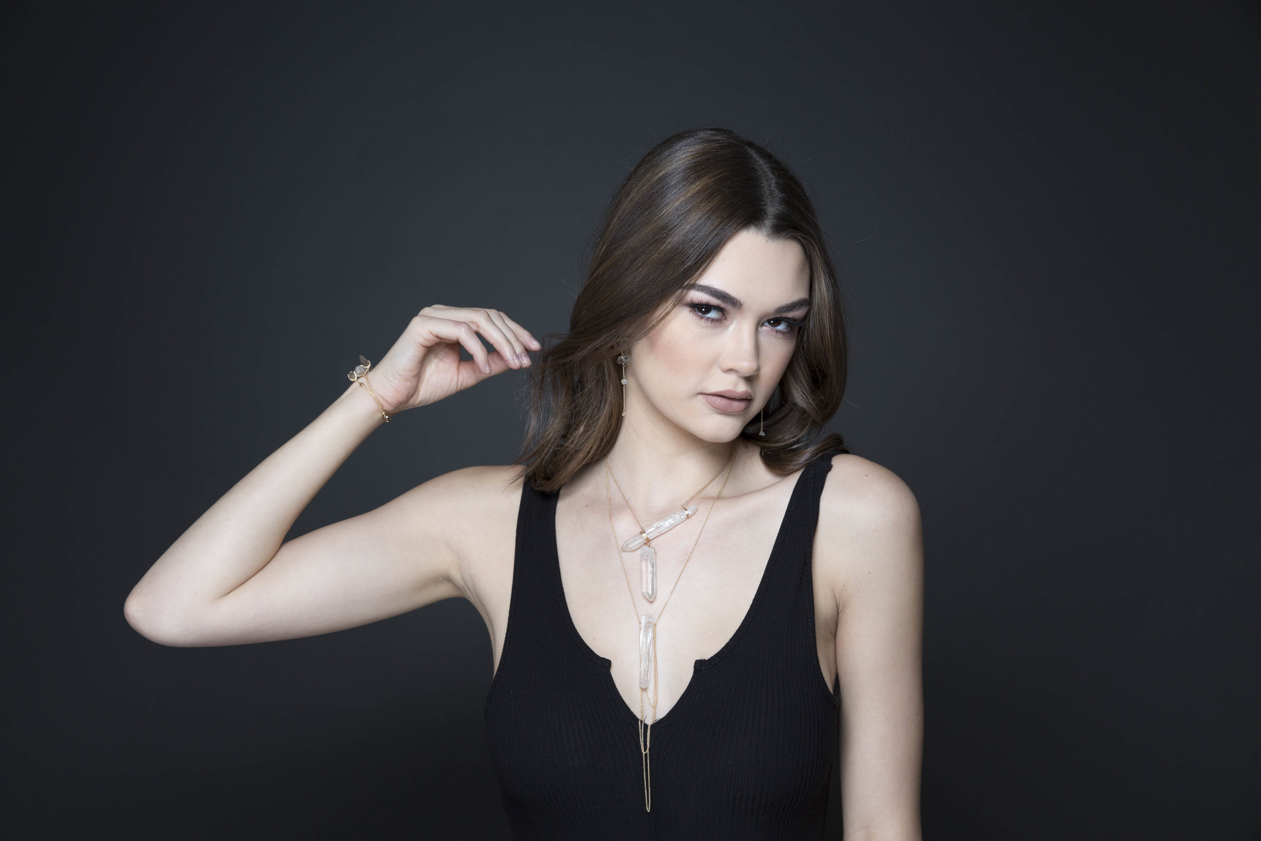 model wearing a crystal point pendant with draping gold chains necklace