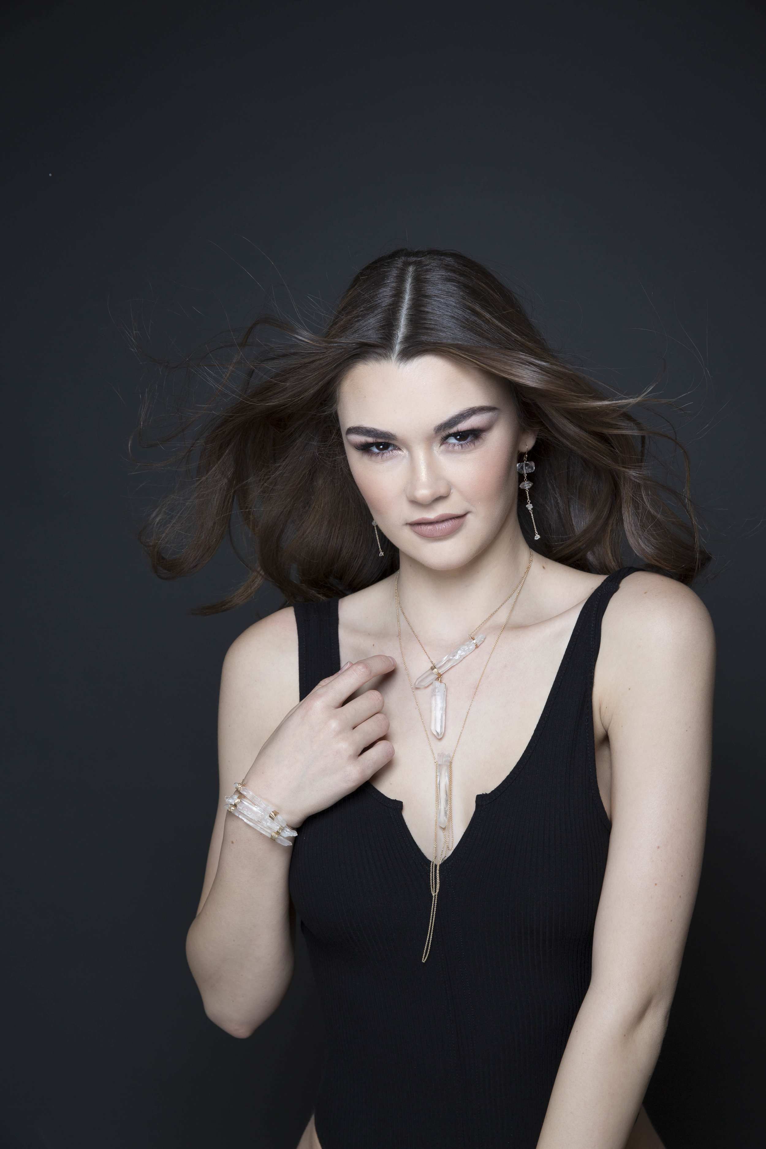 model wearing a crystal point pendant with draping gold chains necklace