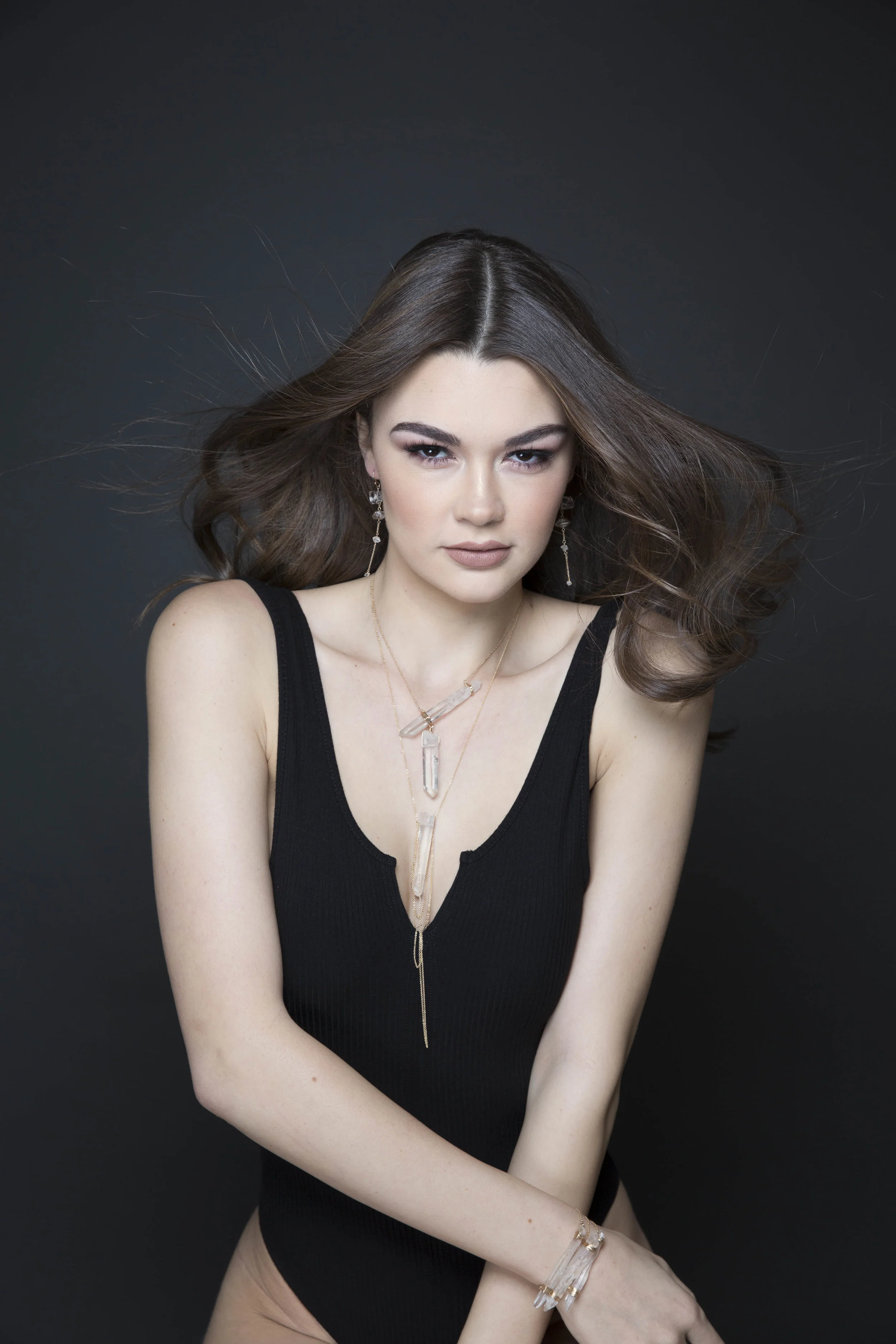 model wearing a crystal point pendant with draping gold chains necklace