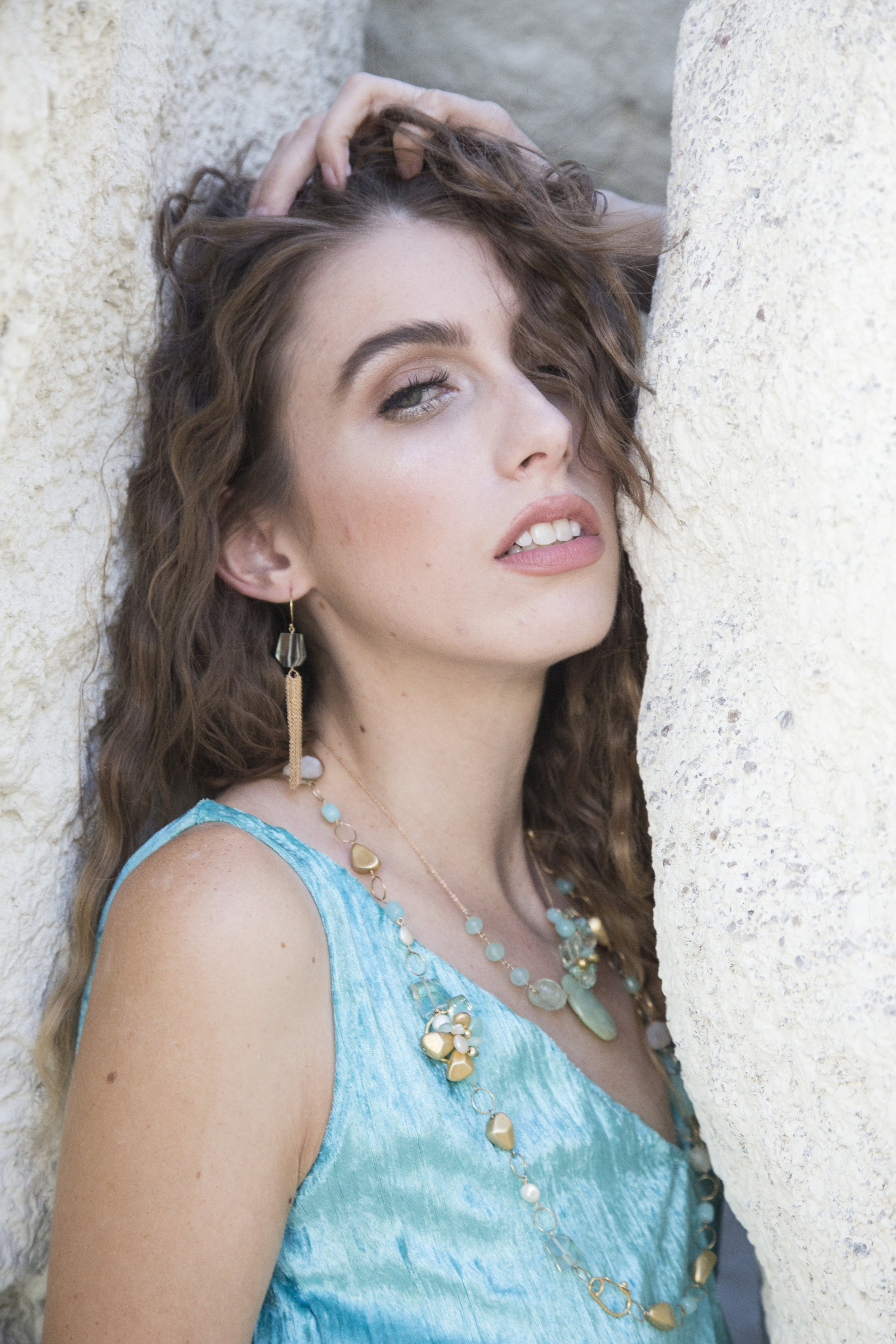 Model wearing green amethyst and gold chain tassel earrings