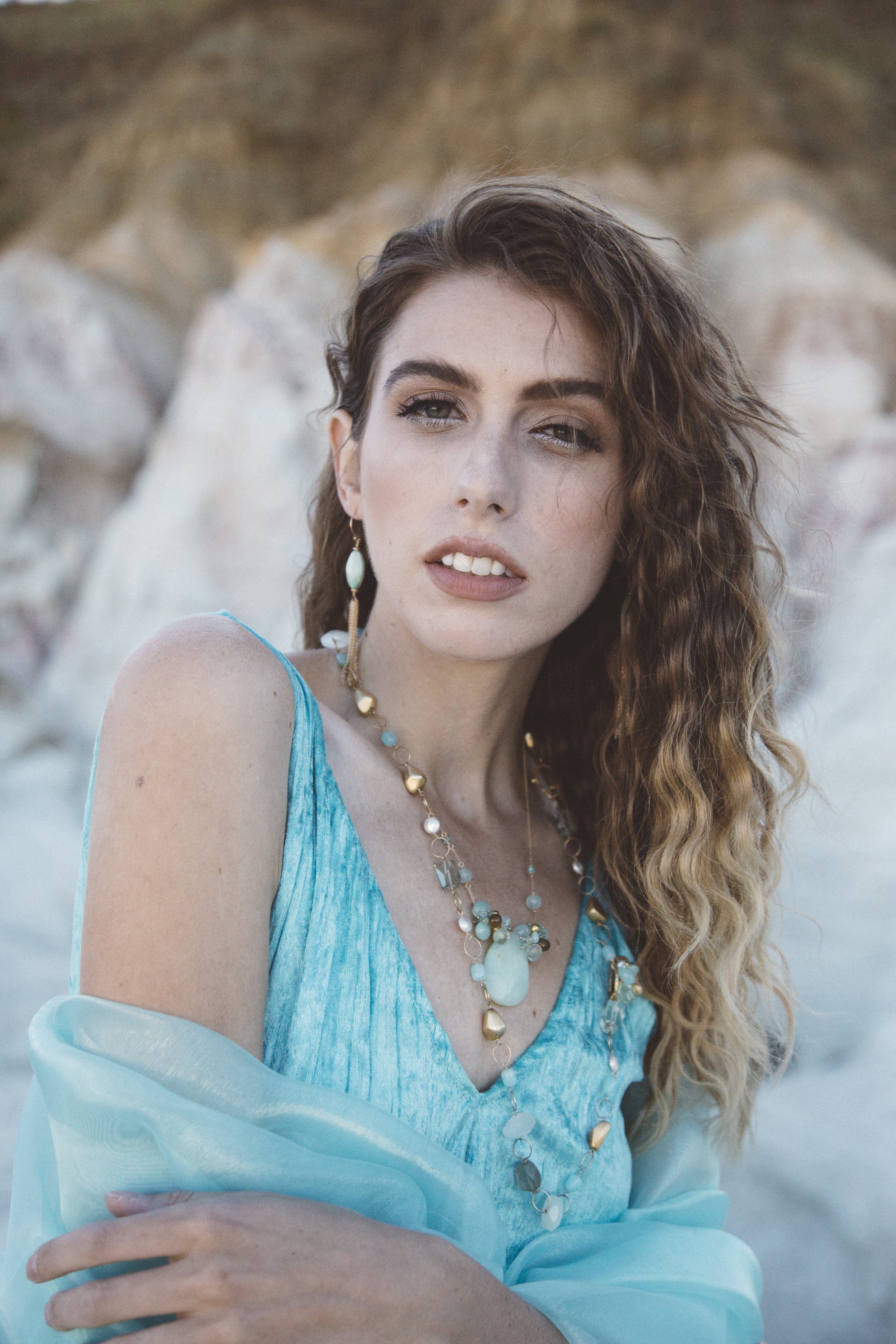 Model wearing a marquis shaped amazonite with gold chain tassel earrings