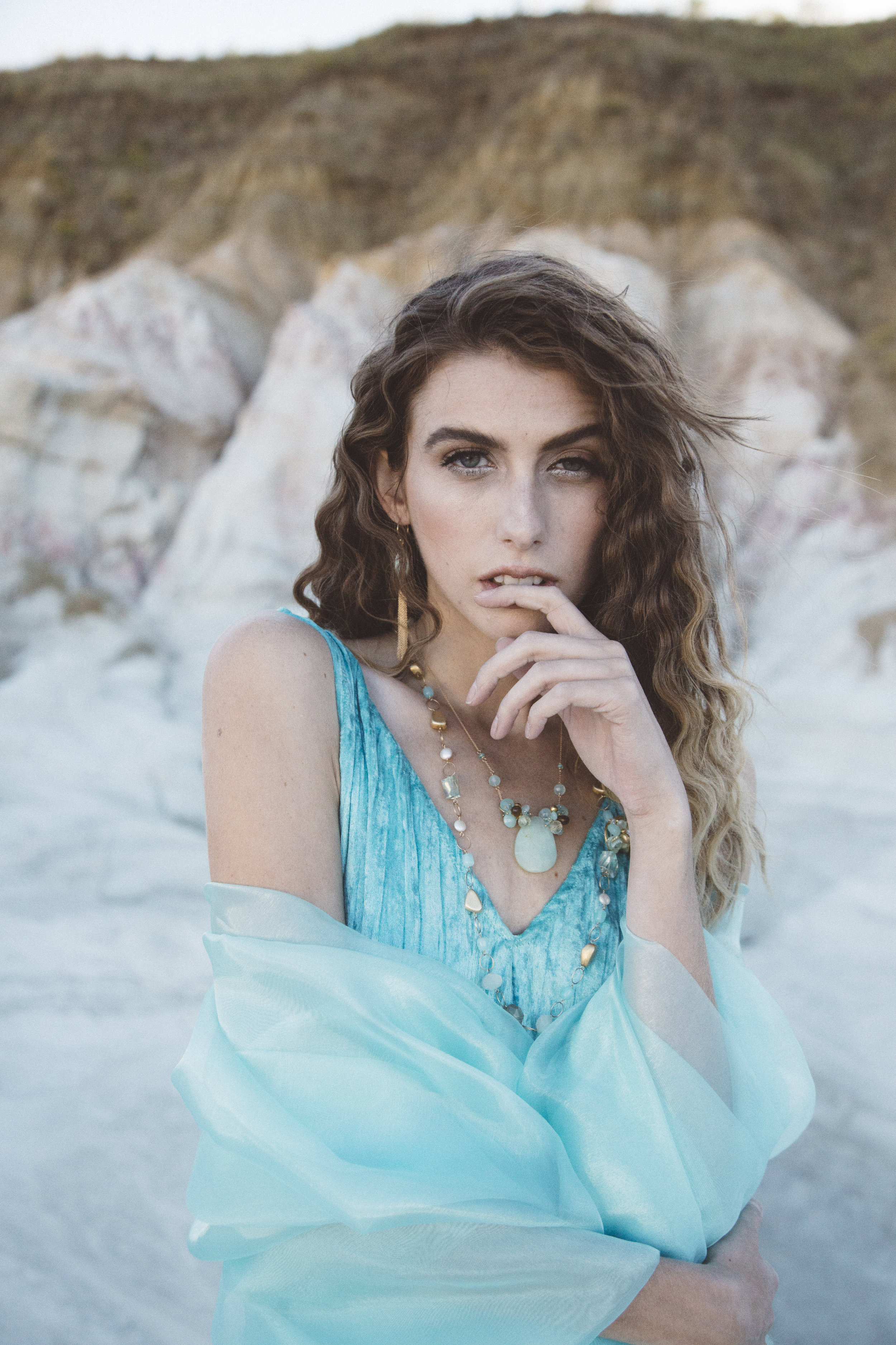 Model wearing a marquis shaped amazonite with gold chain tassel earrings