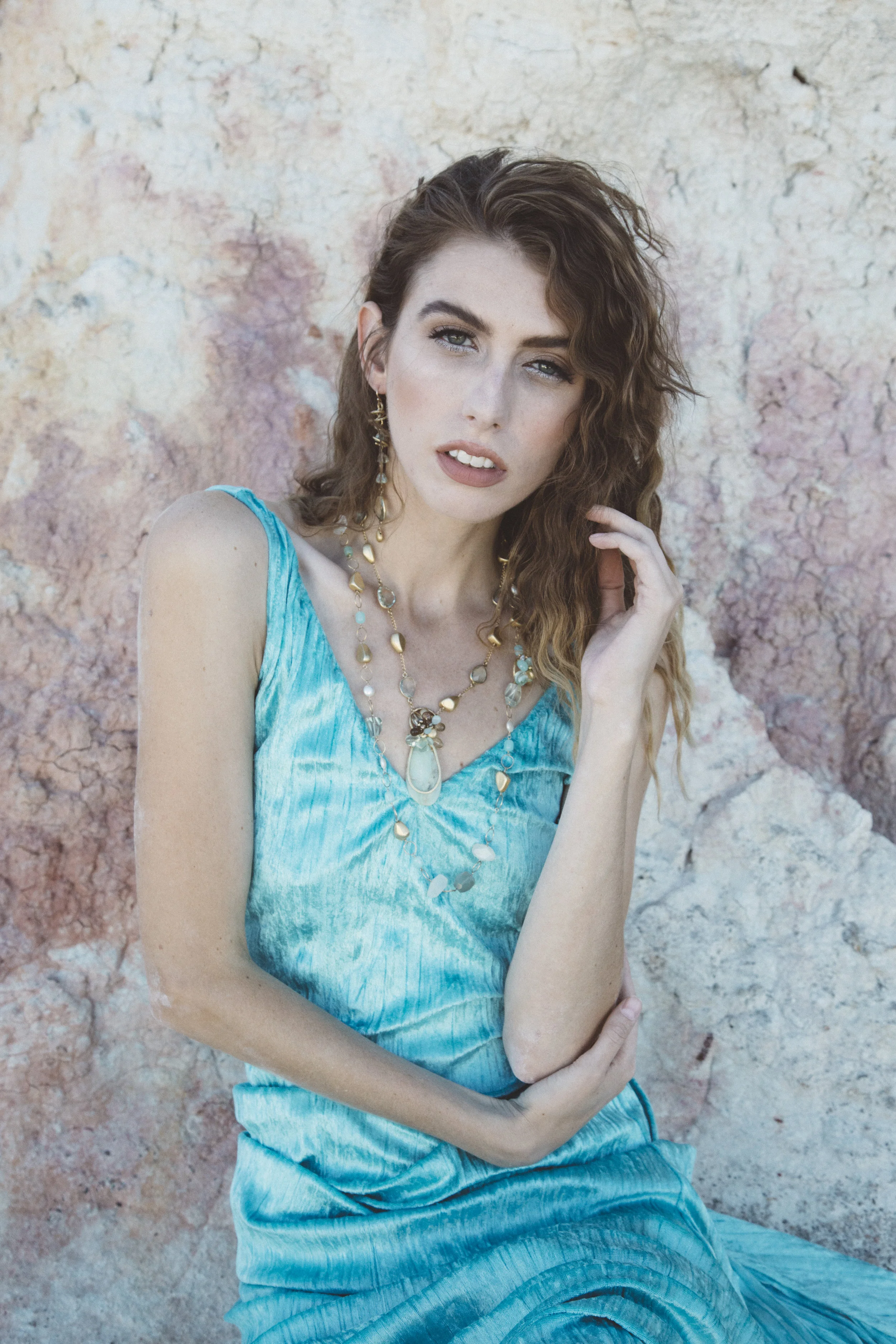model wearing green amethyst with a gold spiral drop earrings