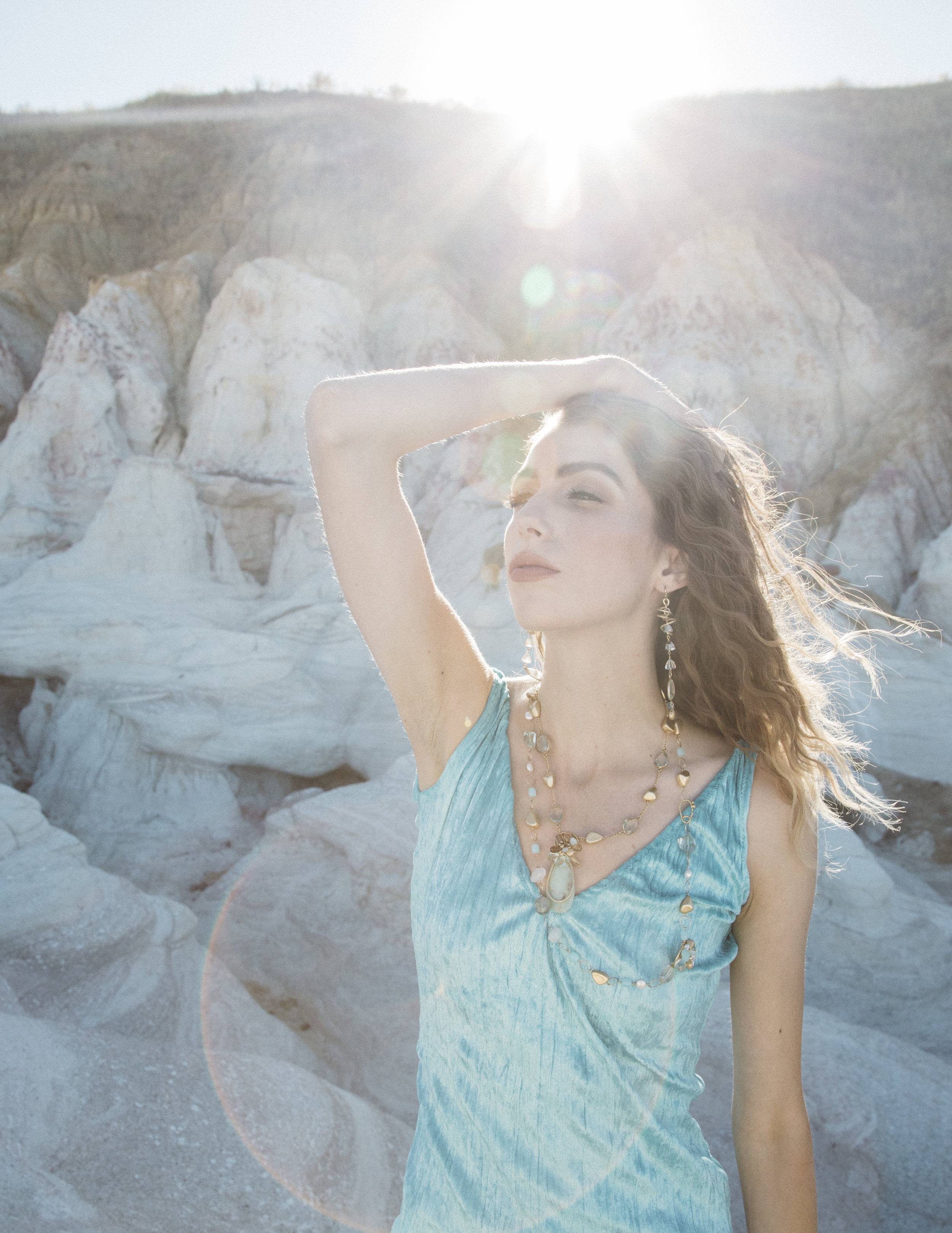 model wearing green amethyst with a gold spiral drop earrings