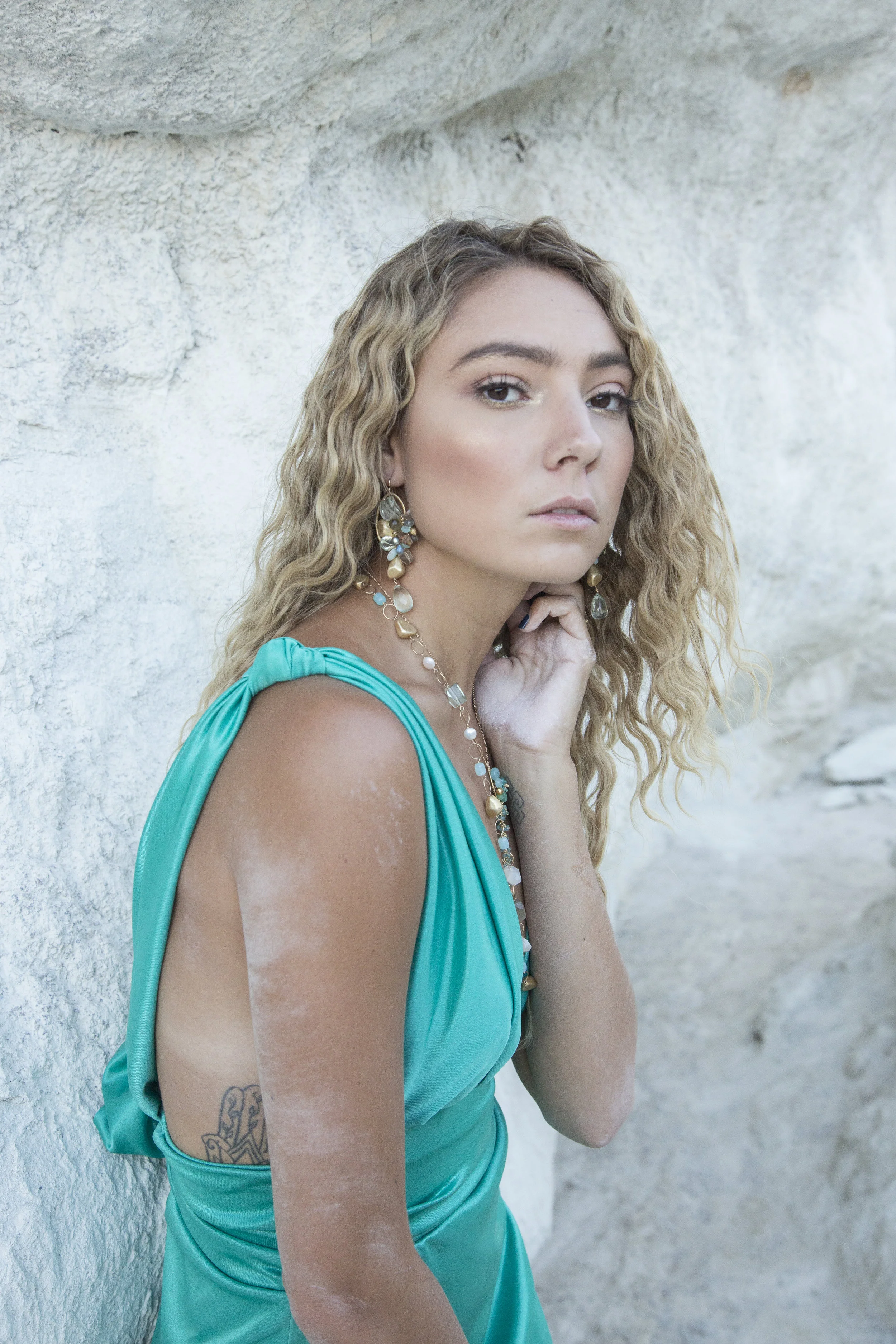 Model wearing gemstone statement earrings