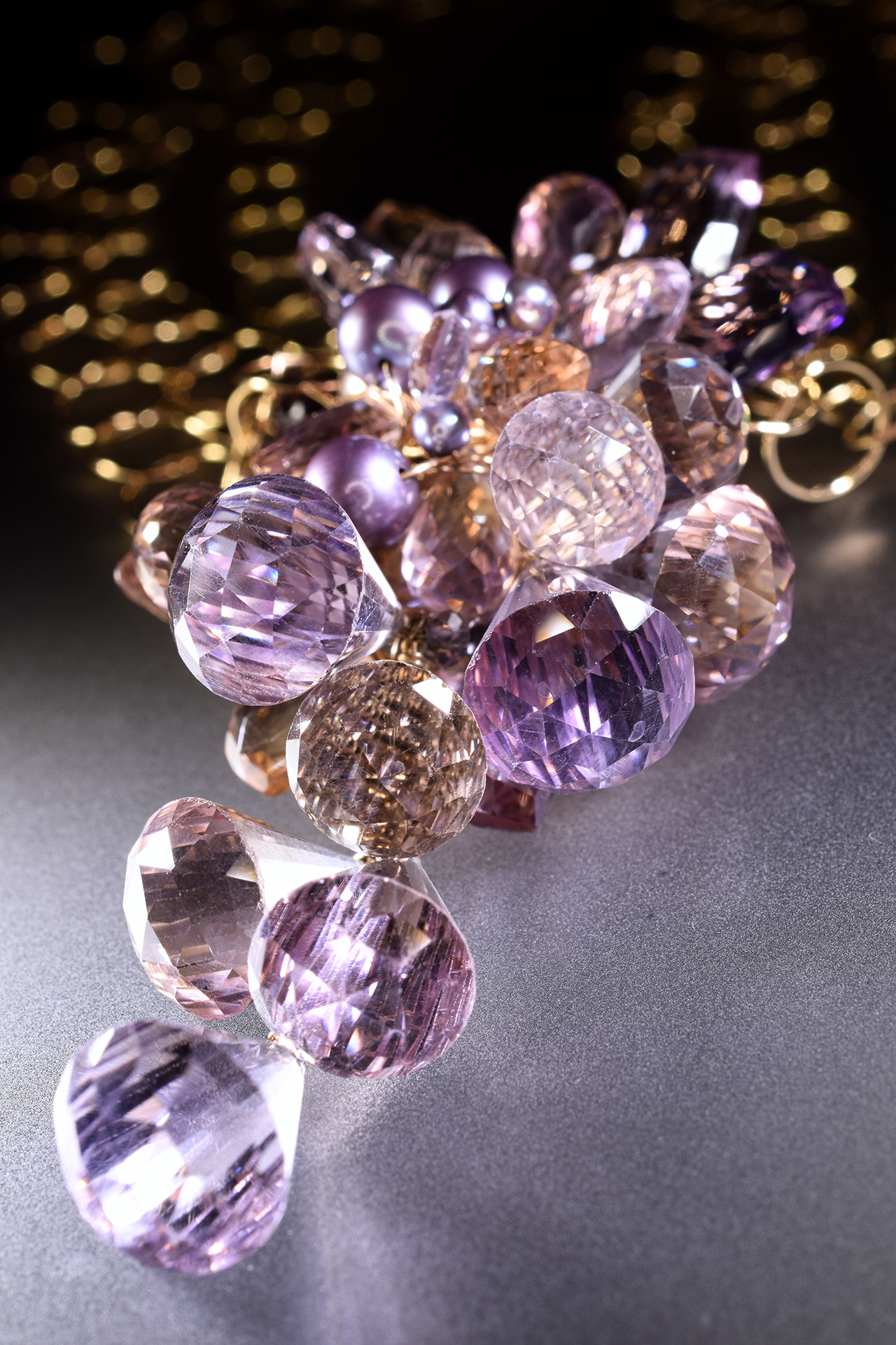 Details of a pink amethyst, ametrine, pearl and gold statement necklace