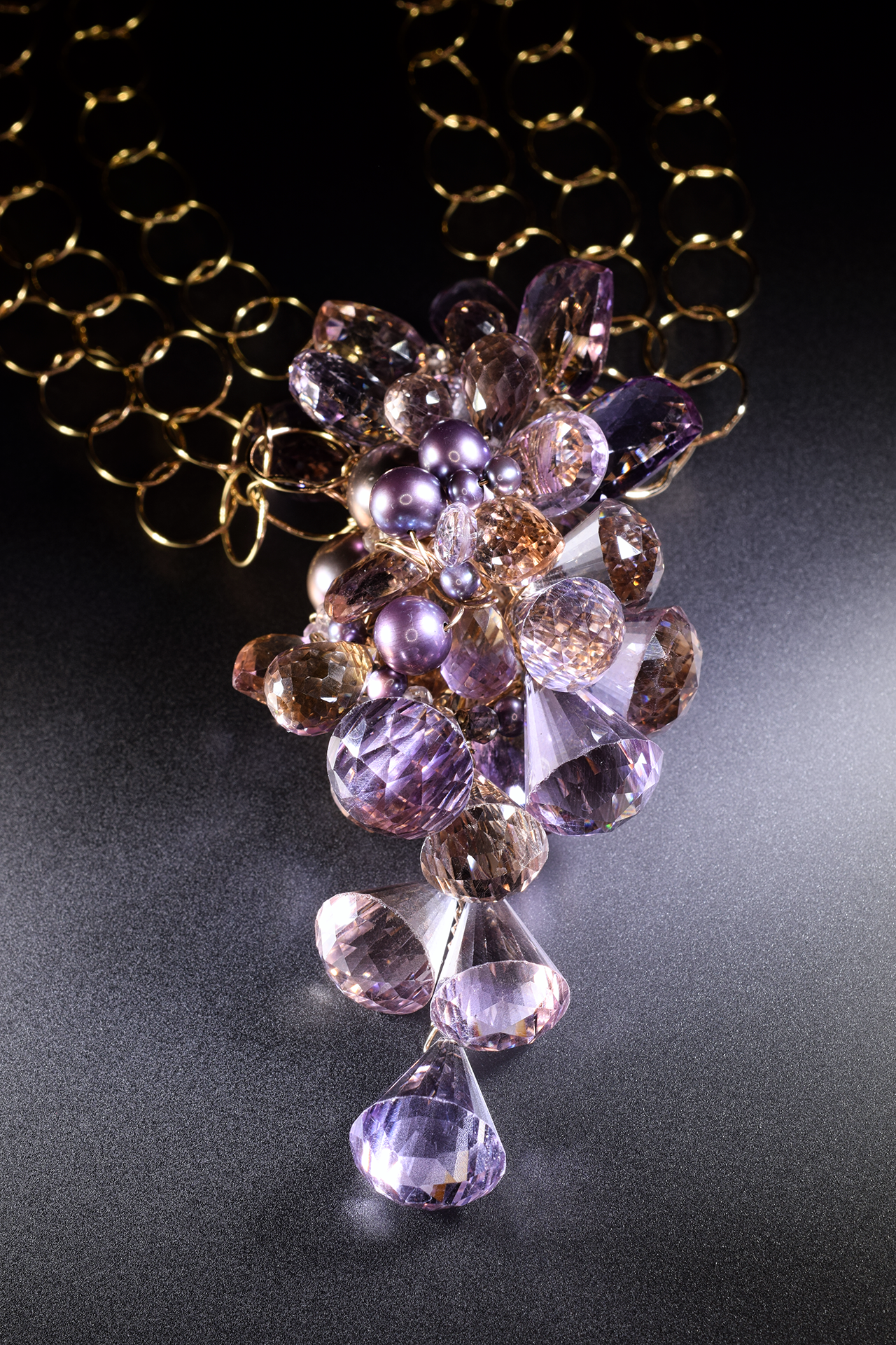 Details of a pink amethyst, ametrine, pearl and gold statement necklace
