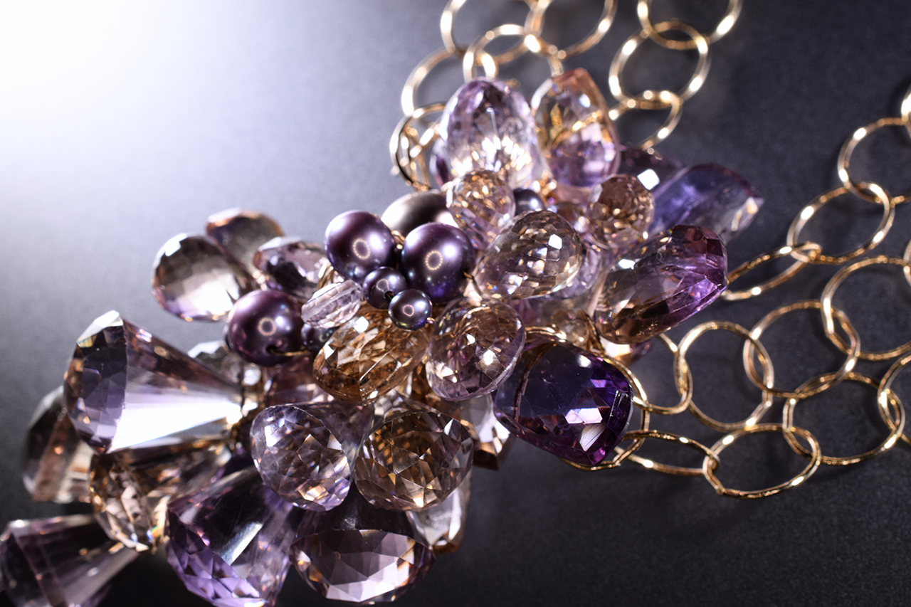 Details of a pink amethyst, ametrine, pearl and gold statement necklace