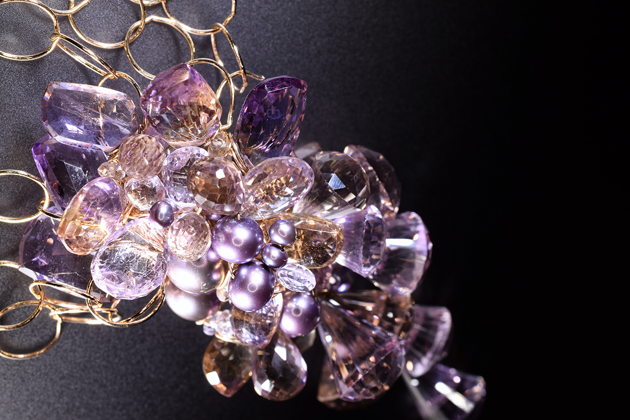 Details of a pink amethyst, ametrine, pearl and gold statement necklace