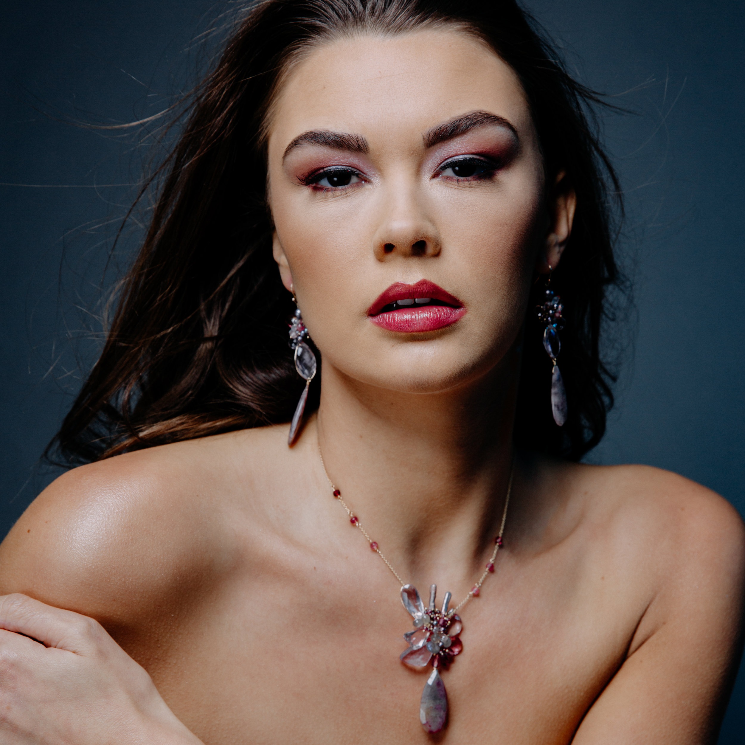 model wearing statement gemstone earrings