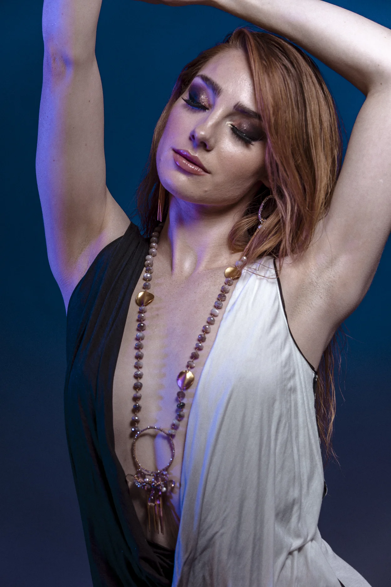 model wearing large circle pendant with gemstone drop with gold spike drops long necklace