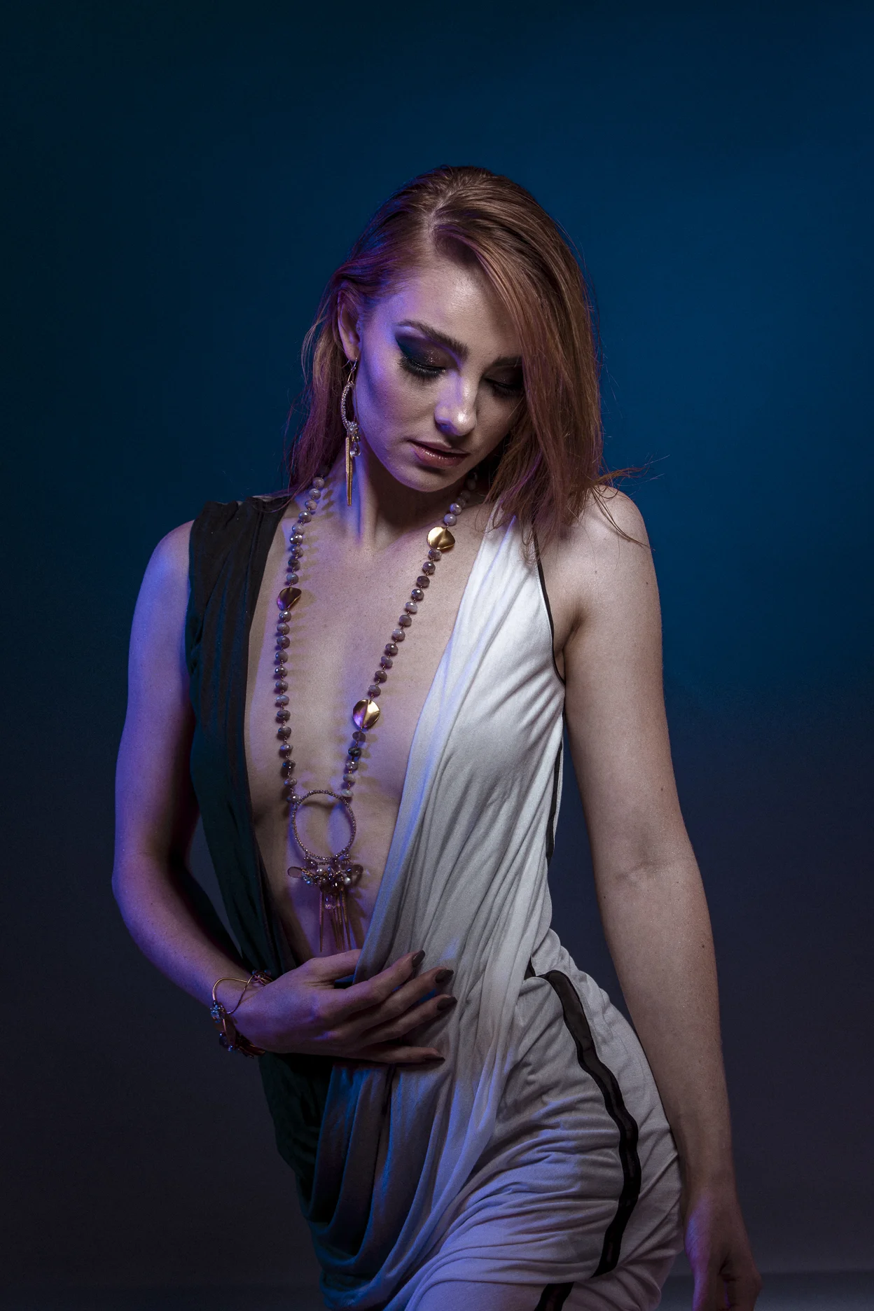 model wearing large circle pendant with gemstone drop with gold spike drops long necklace