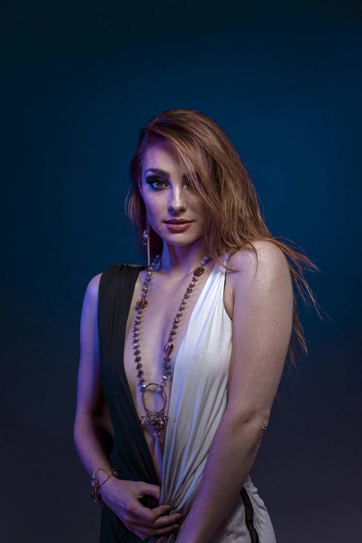 model wearing large circle pendant with gemstone drop with gold spike drops long necklace