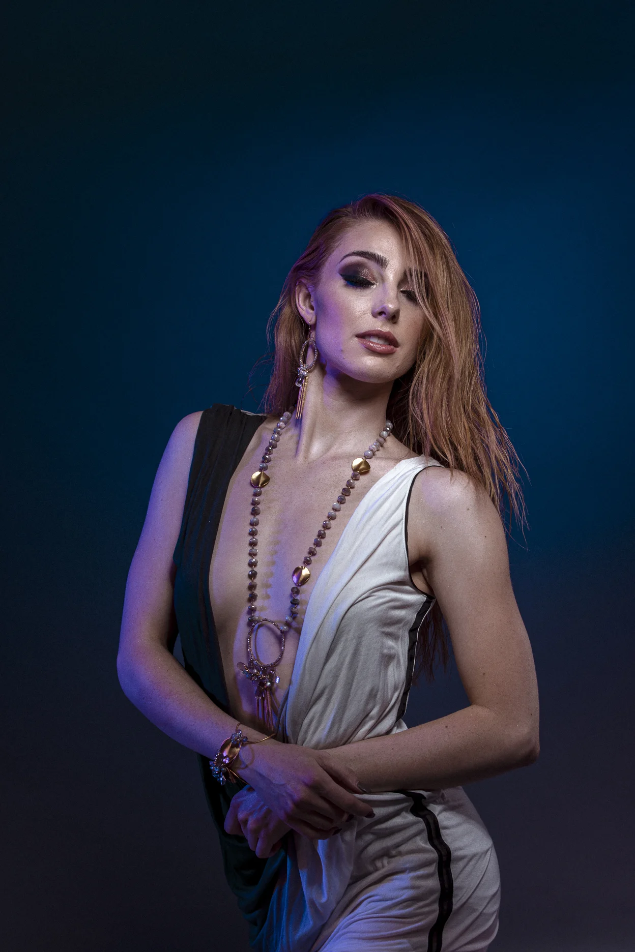 model wearing large circle pendant with gemstone drop with gold spike drops long necklace