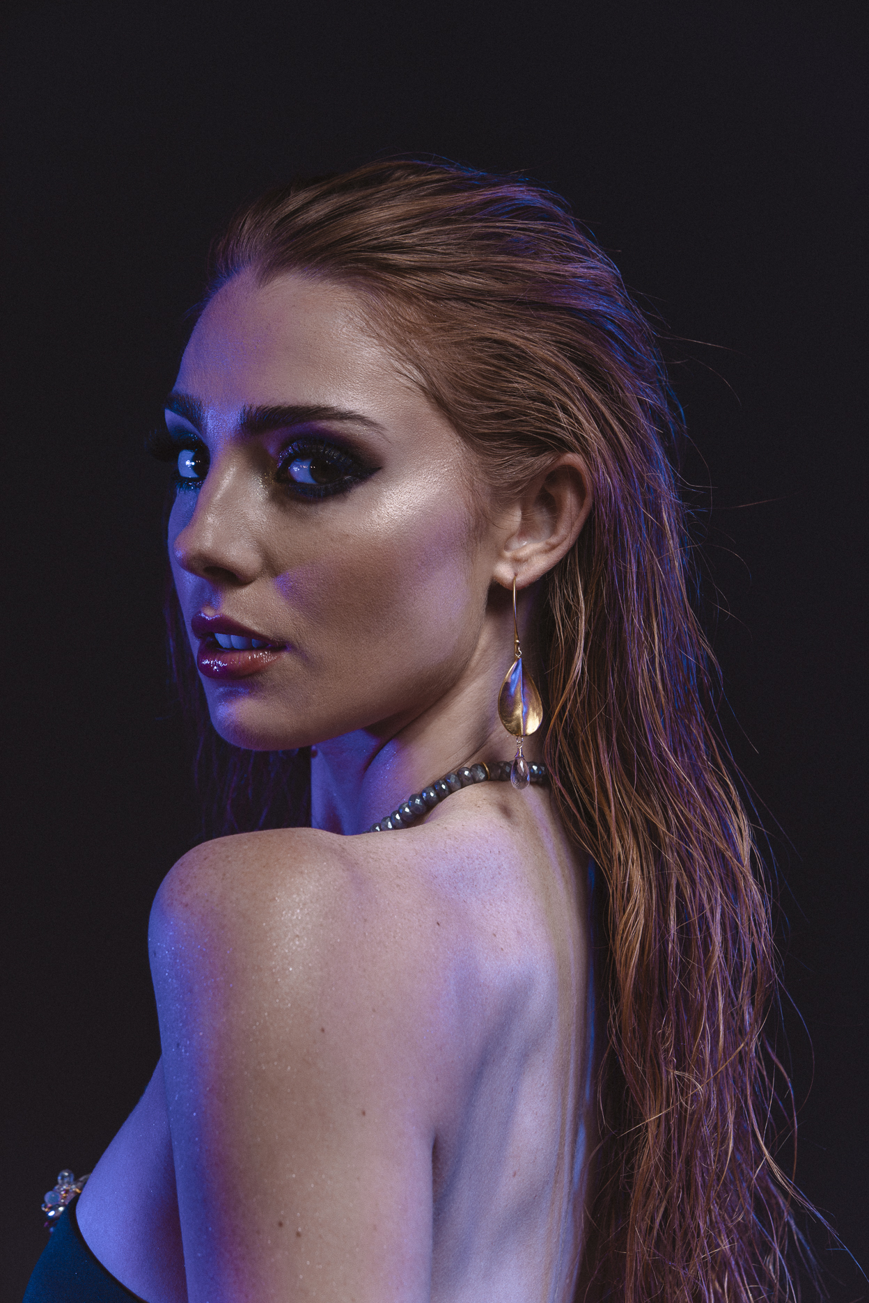 model wearing brushed gold oval drop with gemstone briolettes accents