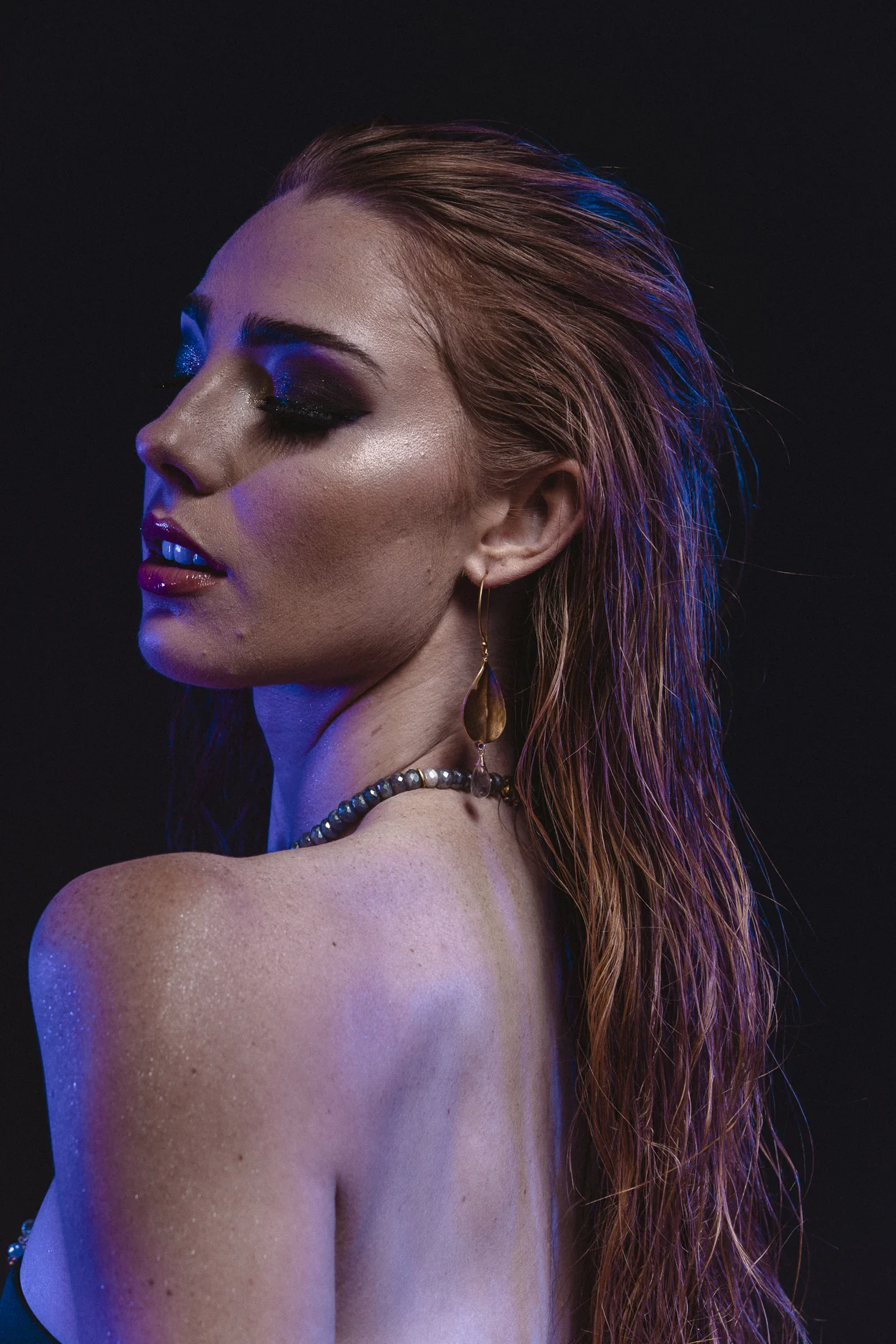 model wearing brushed gold oval drop with gemstone briolettes accent
