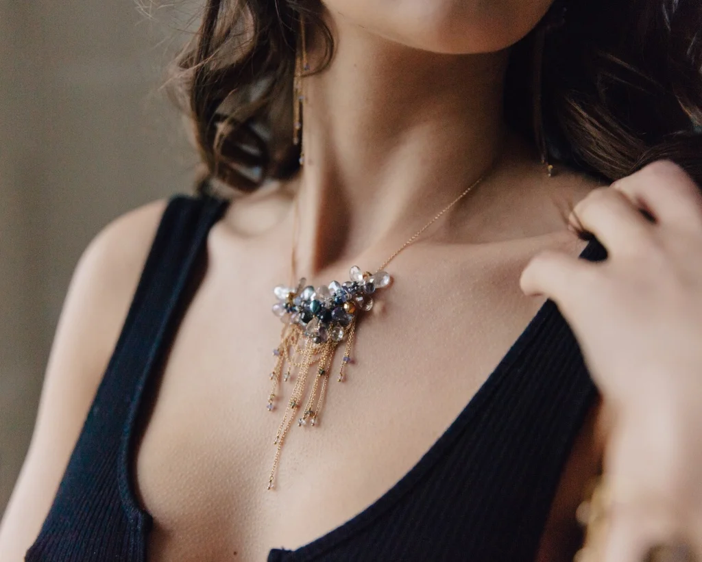 model wearing multi-drop gemstone necklace with delicate gold chains