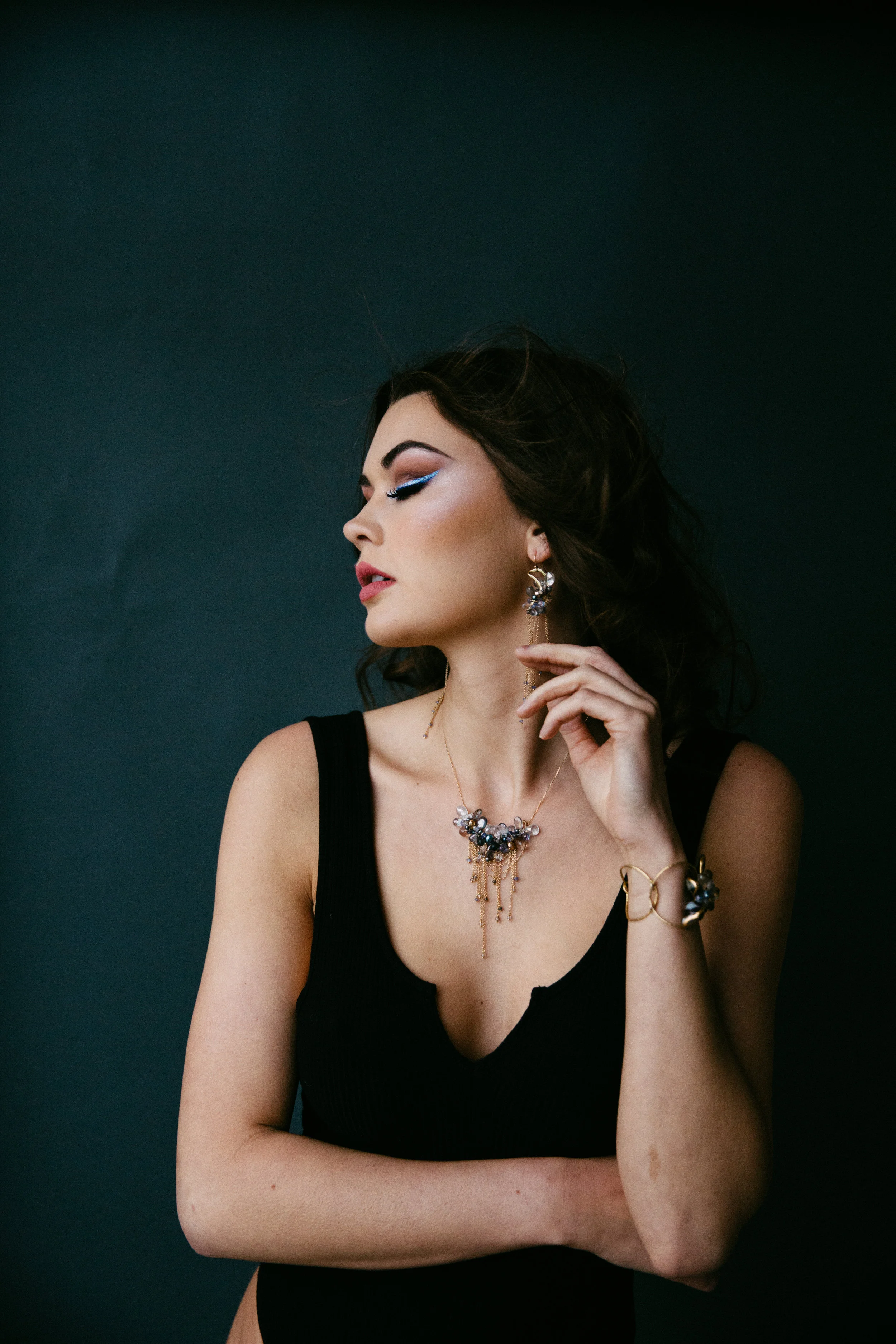 model wearing multi-drop gemstone necklace with delicate gold chains