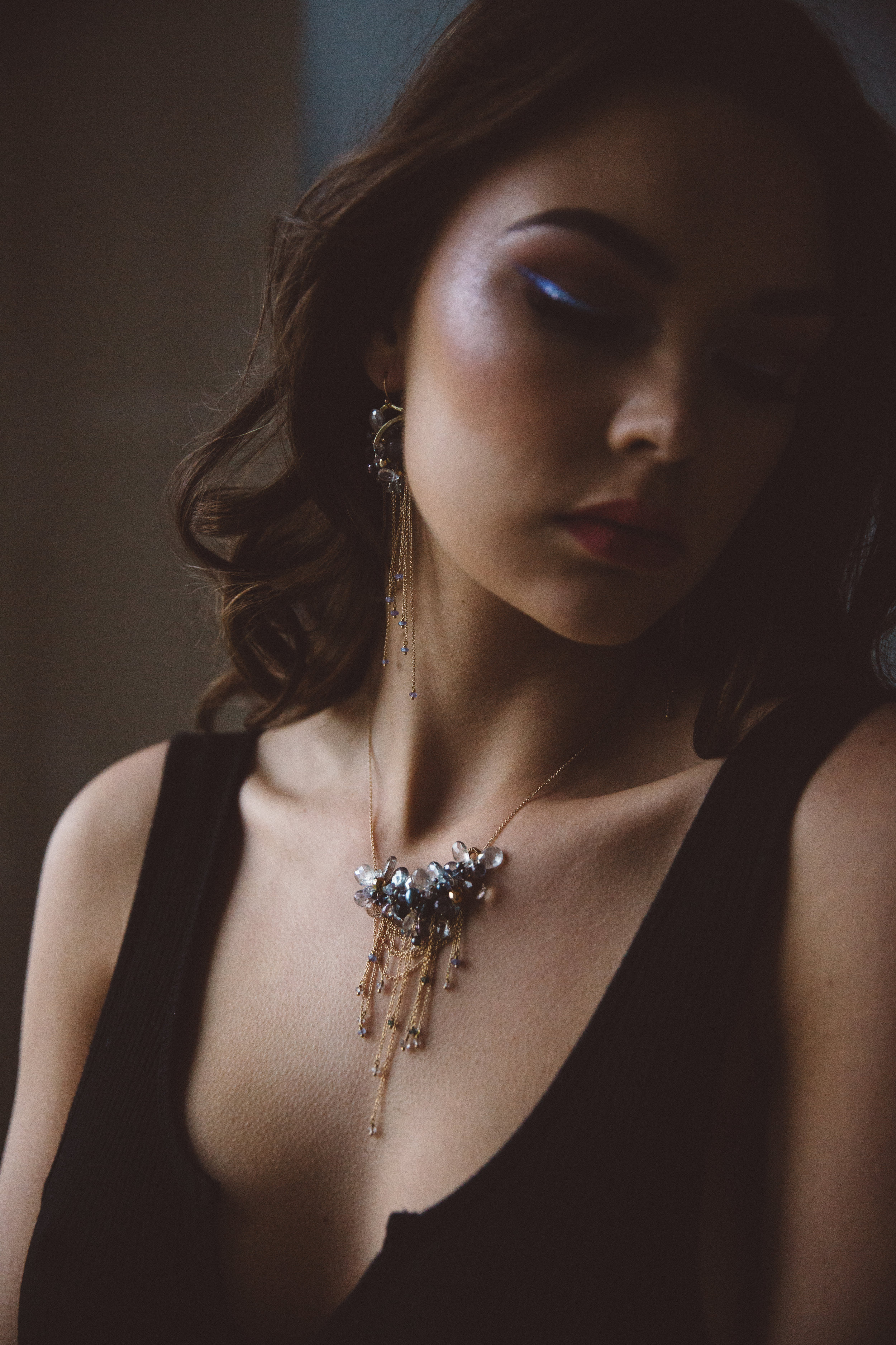 model wearing multi-drop gemstone necklace with delicate gold chains